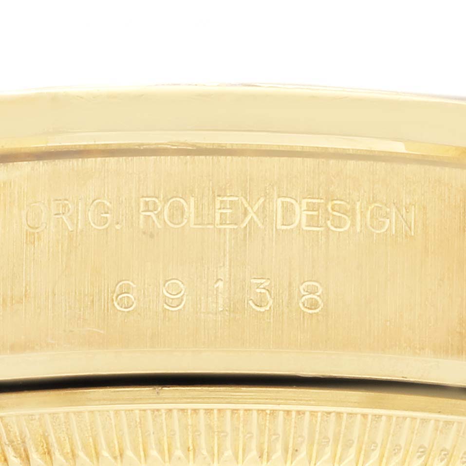 The image shows a close-up of the engraving on the case back of a Rolex President 69138 Women's Yellow Gold Champagne Dial 69138 Women's Yellow Gold Champagne Dial model.