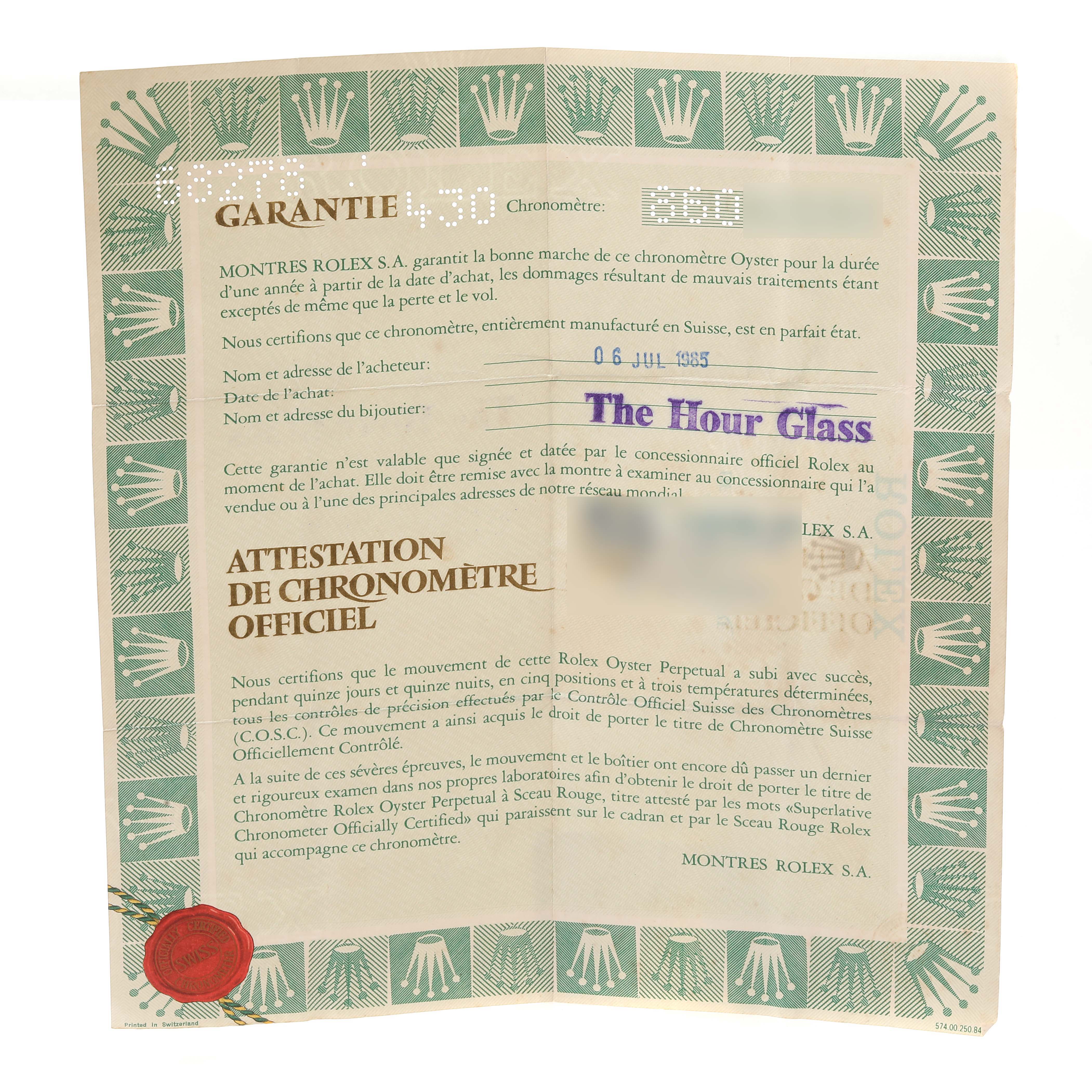 The image shows warranty paperwork angled slightly forward, with a green border featuring Rolex logos.