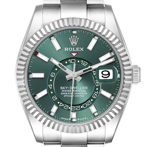 The Rolex Sky-Dweller watch is shown from a front angle, highlighting its green dial, fluted bezel, and cyclops lens date window.