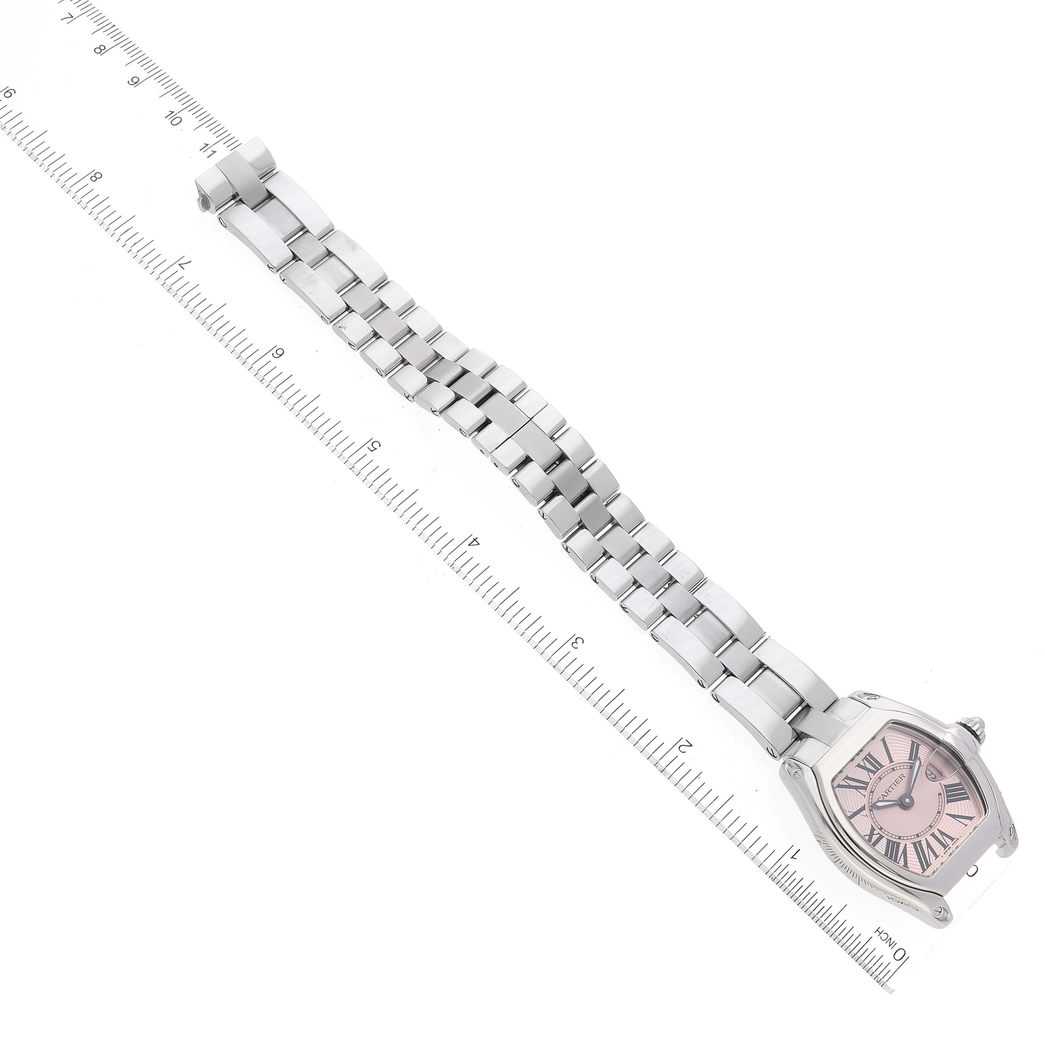 The image shows a Cartier Roadster W62017V3 Women's Stainless Steel Pink Dial W62017V3 Women's Stainless Steel Pink Dial watch laid flat above a ruler, displaying the face, bezel, and entire bracelet.