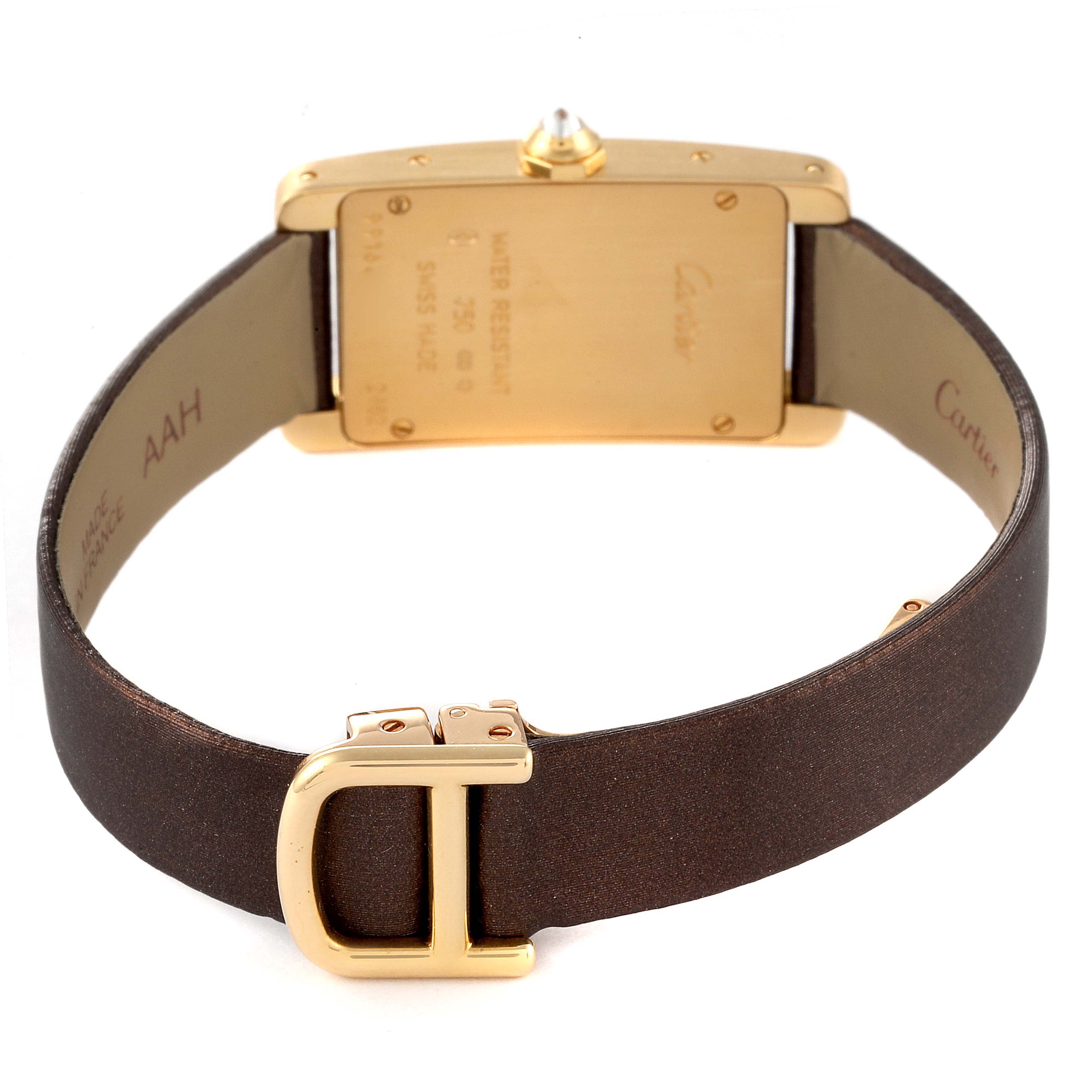 The image shows the back view of the Cartier Tank Americaine 2482 Women's Yellow Gold Brown Dial 2482 Women's Yellow Gold Brown Dial watch, highlighting the case back and a leather strap with a gold buckle.