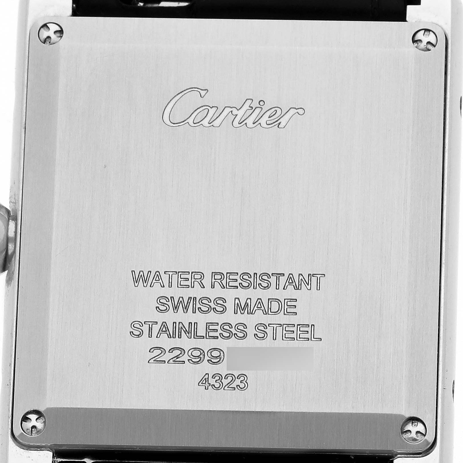 The image shows the back of a Cartier Tank Must WSTA0108 Women's Stainless Steel Black Dial watch, highlighting the engravings and screws.