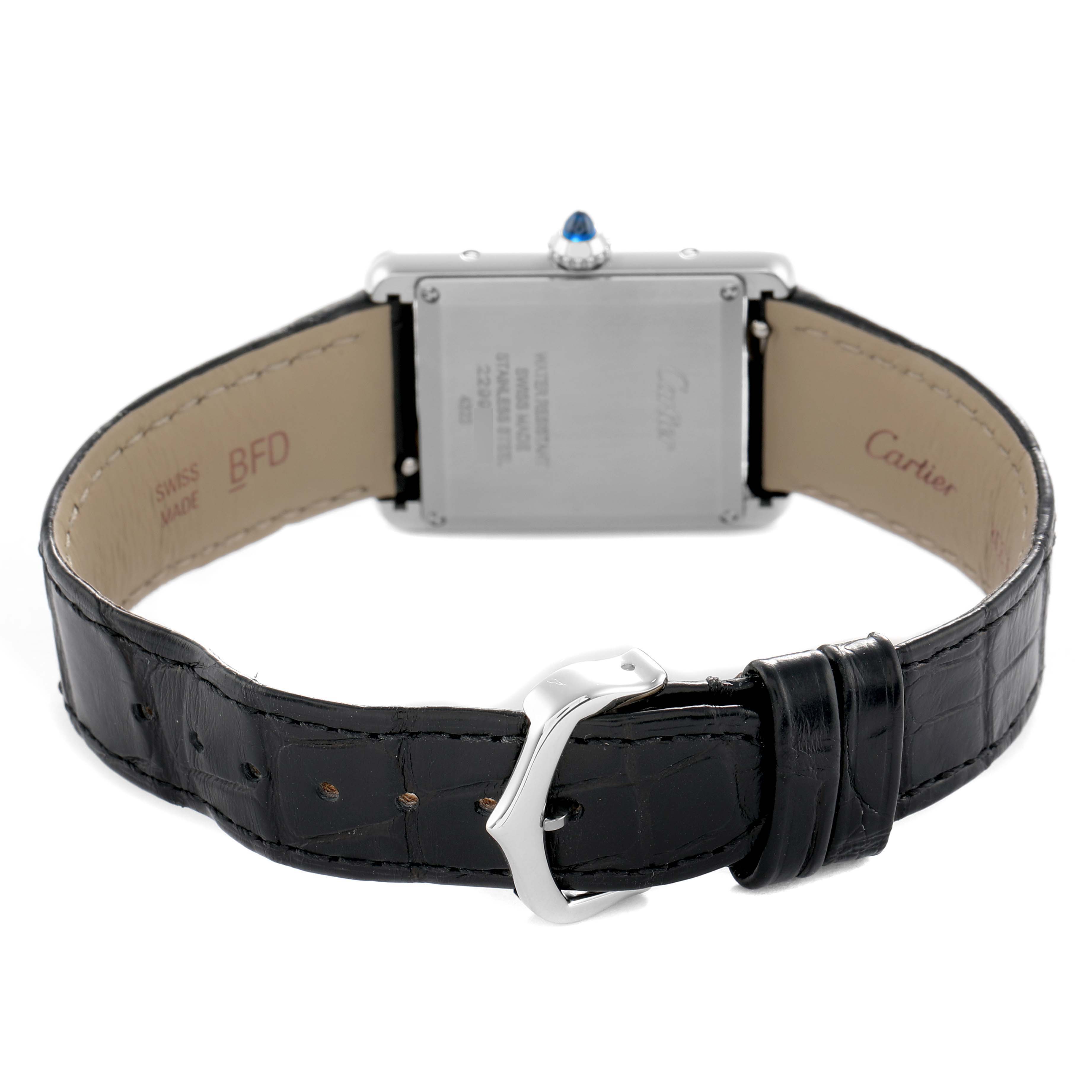 The image shows the back of a Cartier Tank Must WSTA0108 Women's Stainless Steel Black Dial watch, highlighting the clasp, strap, and caseback details.