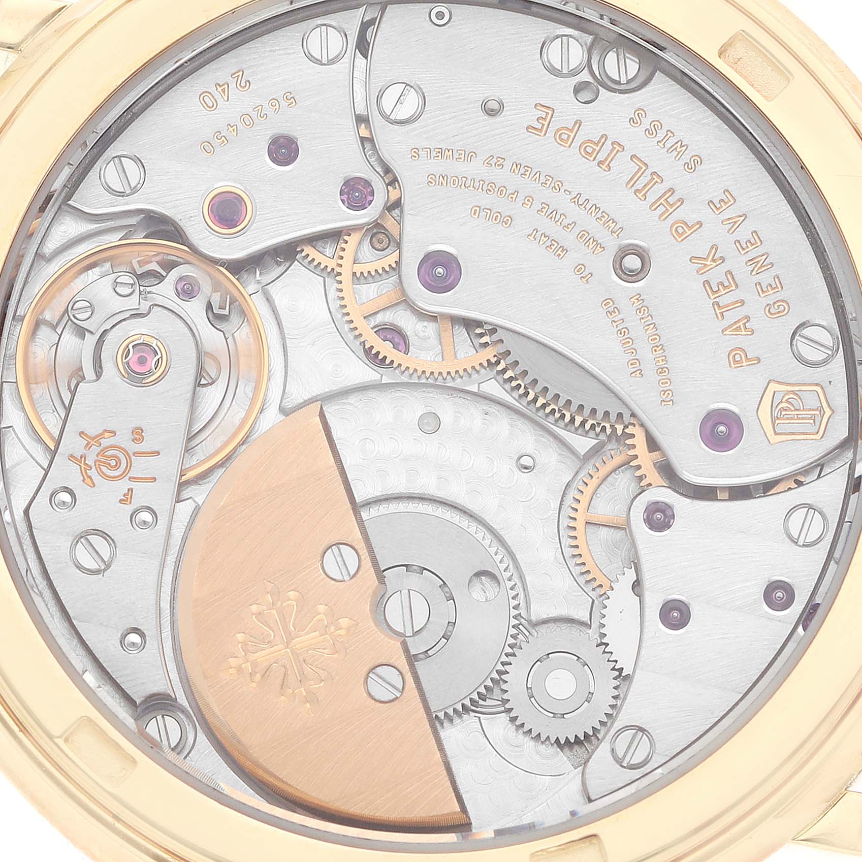 This image shows the intricate back mechanism of a Patek Philippe Calatrava 5120J Men's Yellow Gold White Dial 5120J Men's Yellow Gold White Dial watch, highlighting gears, screws, and engravings.