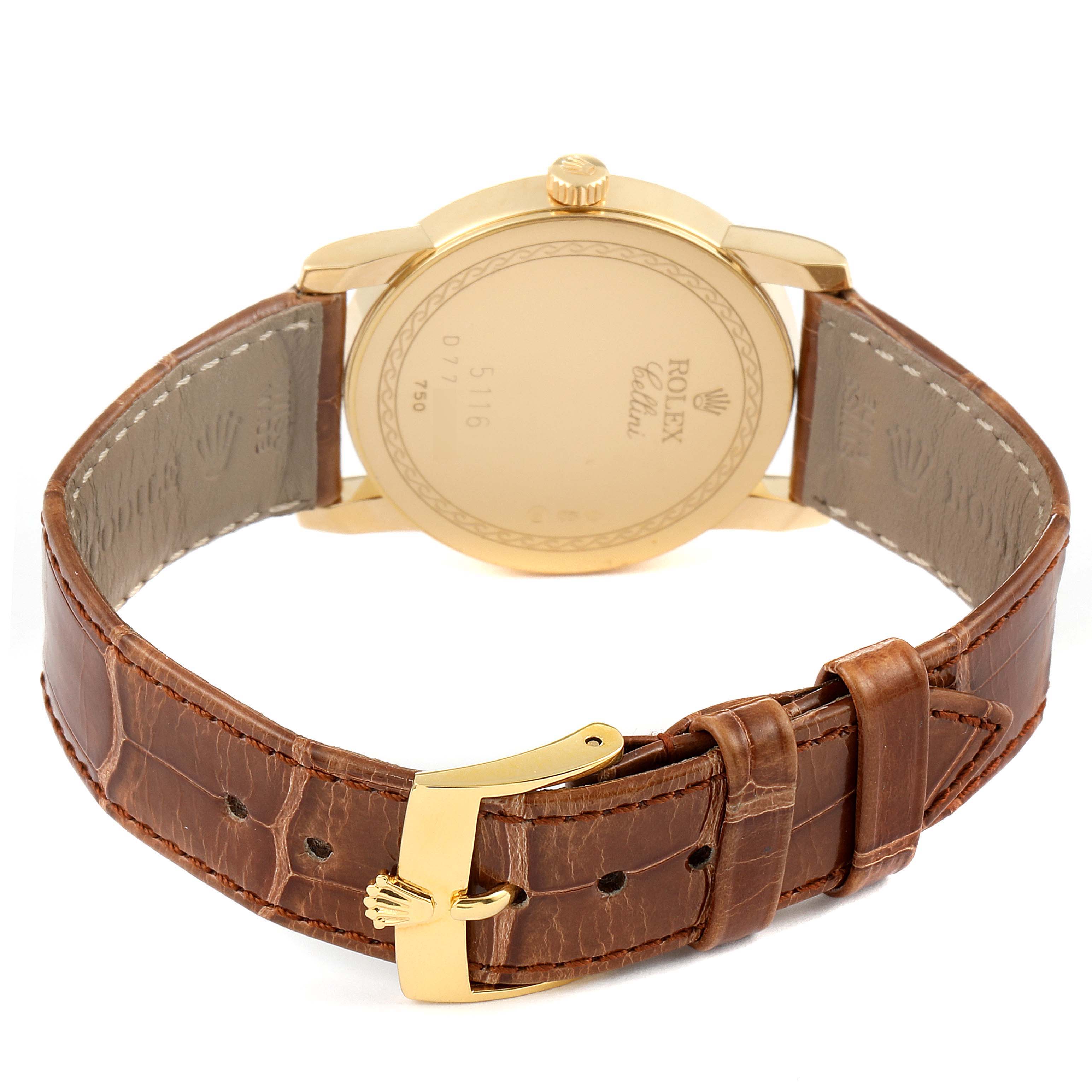 The image shows the back view of a Rolex Cellini 5116 Men's Yellow Gold Champagne Dial 5116 Men's Yellow Gold Champagne Dial watch with its gold case and brown leather strap with a gold buckle.