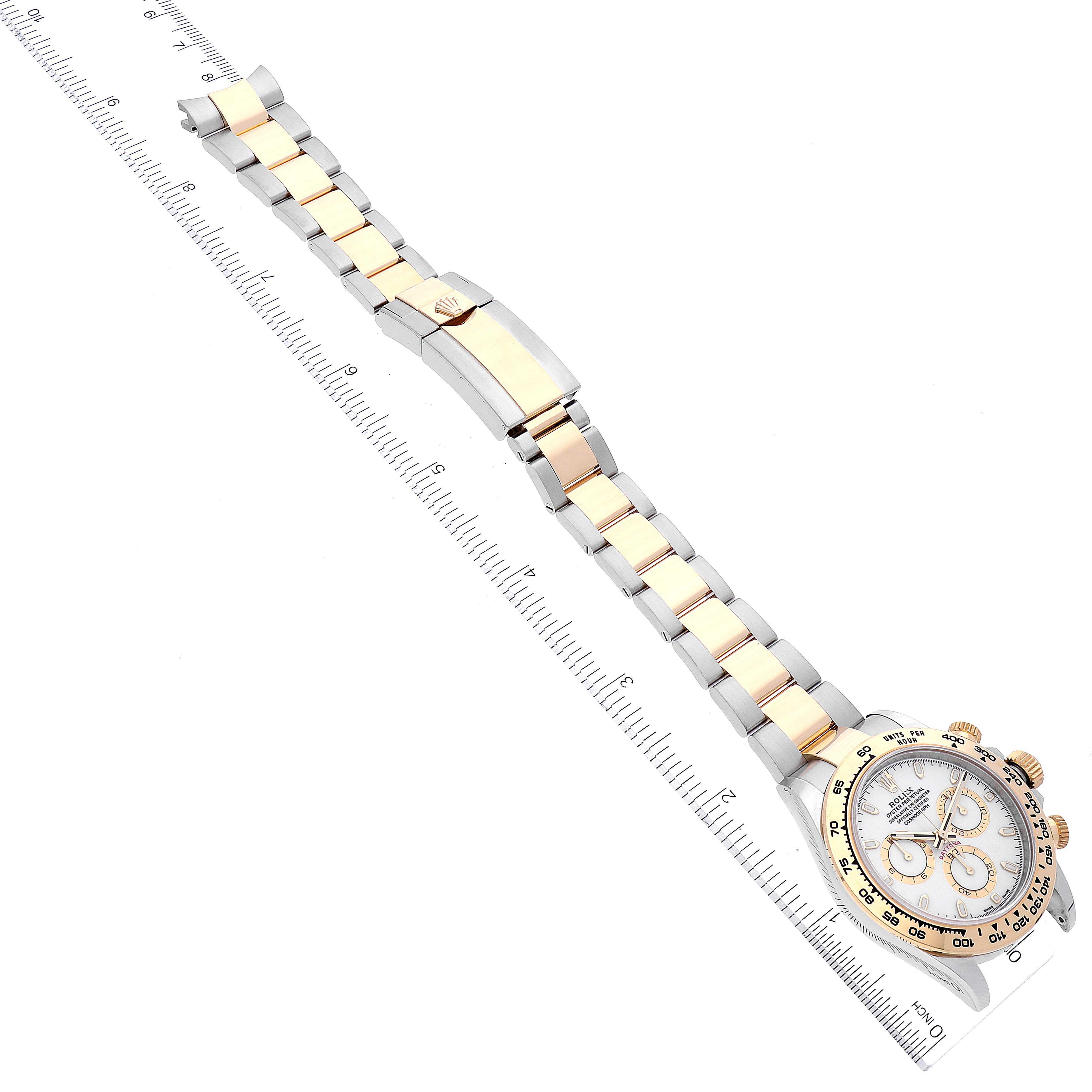 This image shows a top-angle view of a Rolex Daytona 116503 Men's Steel and Gold (two tone) White Dial 116503 Men's Steel and Gold (two tone) White Dial watch, illustrating its band and face alongside a ruler for scale.