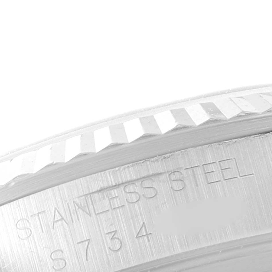 The image shows a close-up of the fluted bezel and part of the casing with engraved text on a Rolex Datejust 16234 Men's Stainless Steel Black Dial 16234 Men's Stainless Steel Black Dial watch.