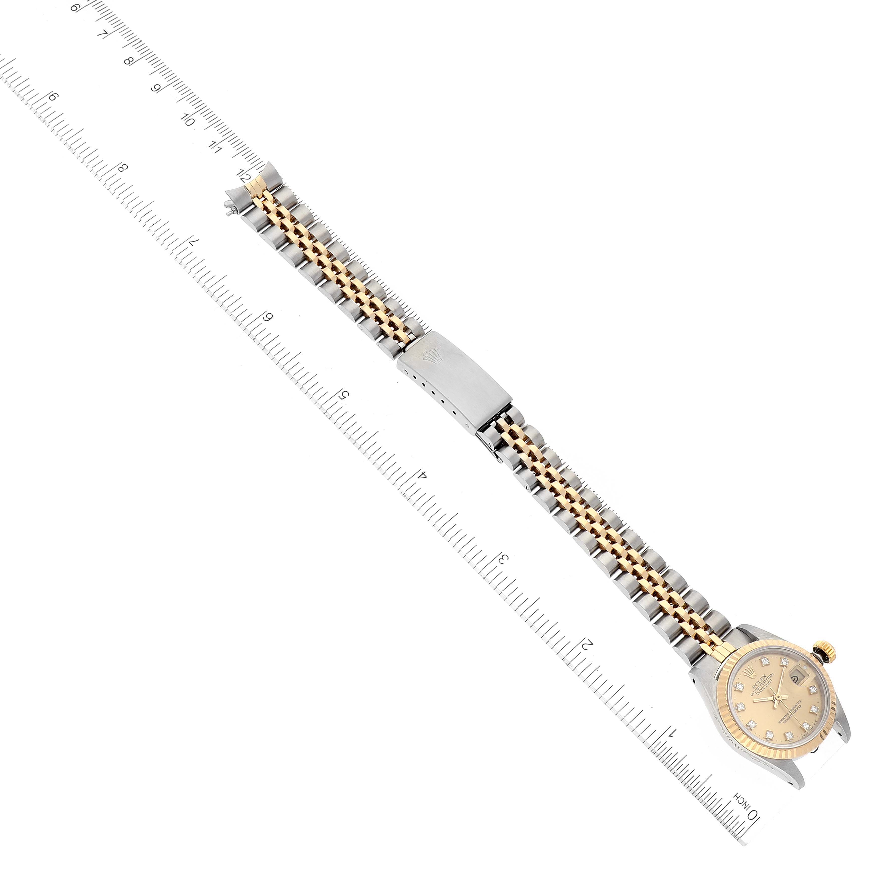 This image shows a Rolex Datejust 69173 Women's Steel and Gold (two tone) Champagne Dial 69173 Women's Steel and Gold (two tone) Champagne Dial watch, with the focus on its dial, bezel, and two-tone bracelet, positioned alongside a ruler.