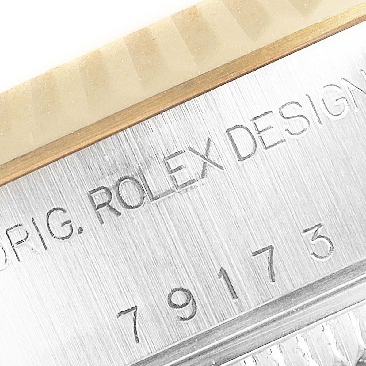 The image shows a close-up of the serial number and "Rolex Design" engraving on the case of a Rolex Datejust 79173 Women
s Steel and Gold (two tone) Champagne Dial 79173 Women
s Steel and Gold (two tone) Champagne Dial watch.