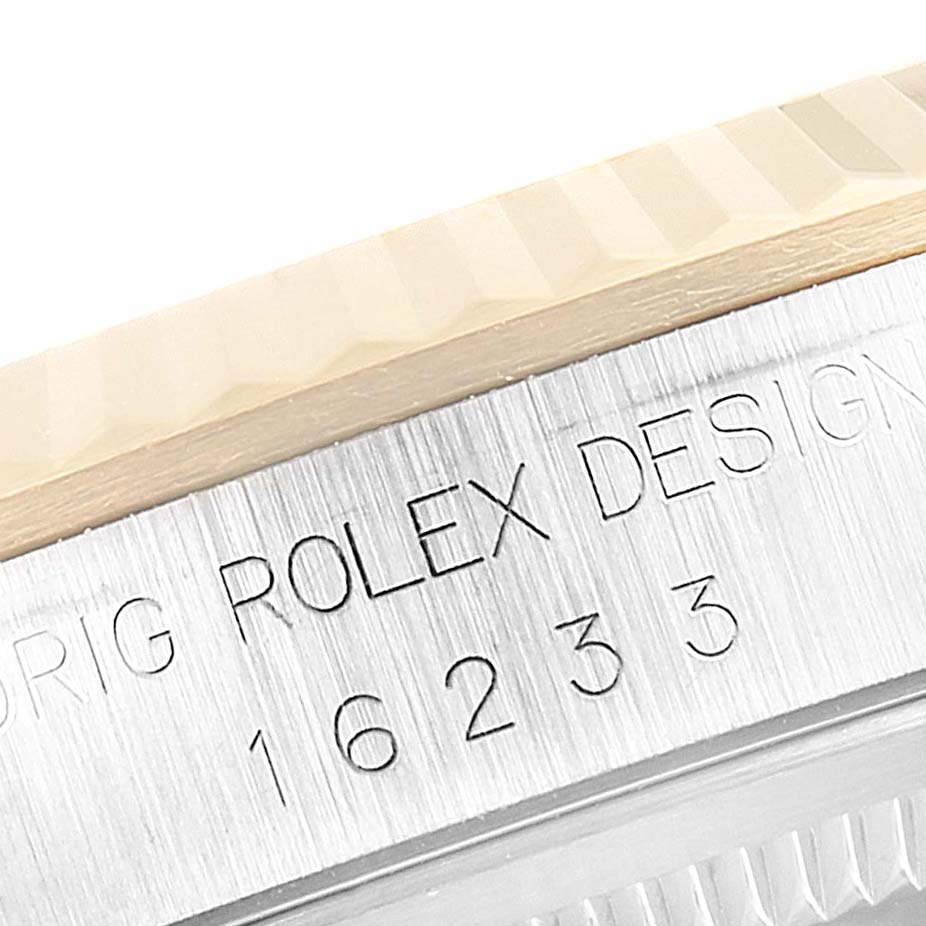 The image shows a close-up of the fluted bezel and engraved case side of a Rolex Datejust 16233 Men
s Steel and Gold (two tone) Grey Dial 16233 Men
s Steel and Gold (two tone) Grey Dial watch.