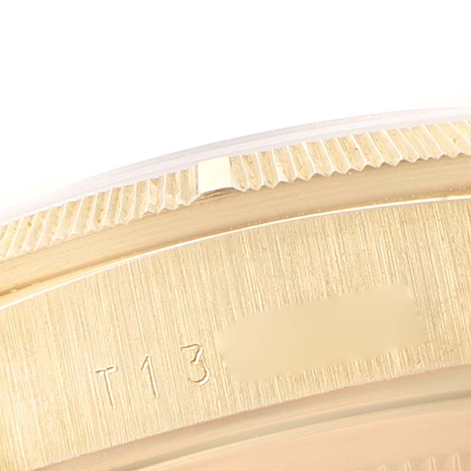 This image shows a close-up of the side view of a Rolex President 18248 Men's Yellow Gold Champagne Dial 18248 Men's Yellow Gold Champagne Dial model watch case, focusing on the engraved serial number and bezel.