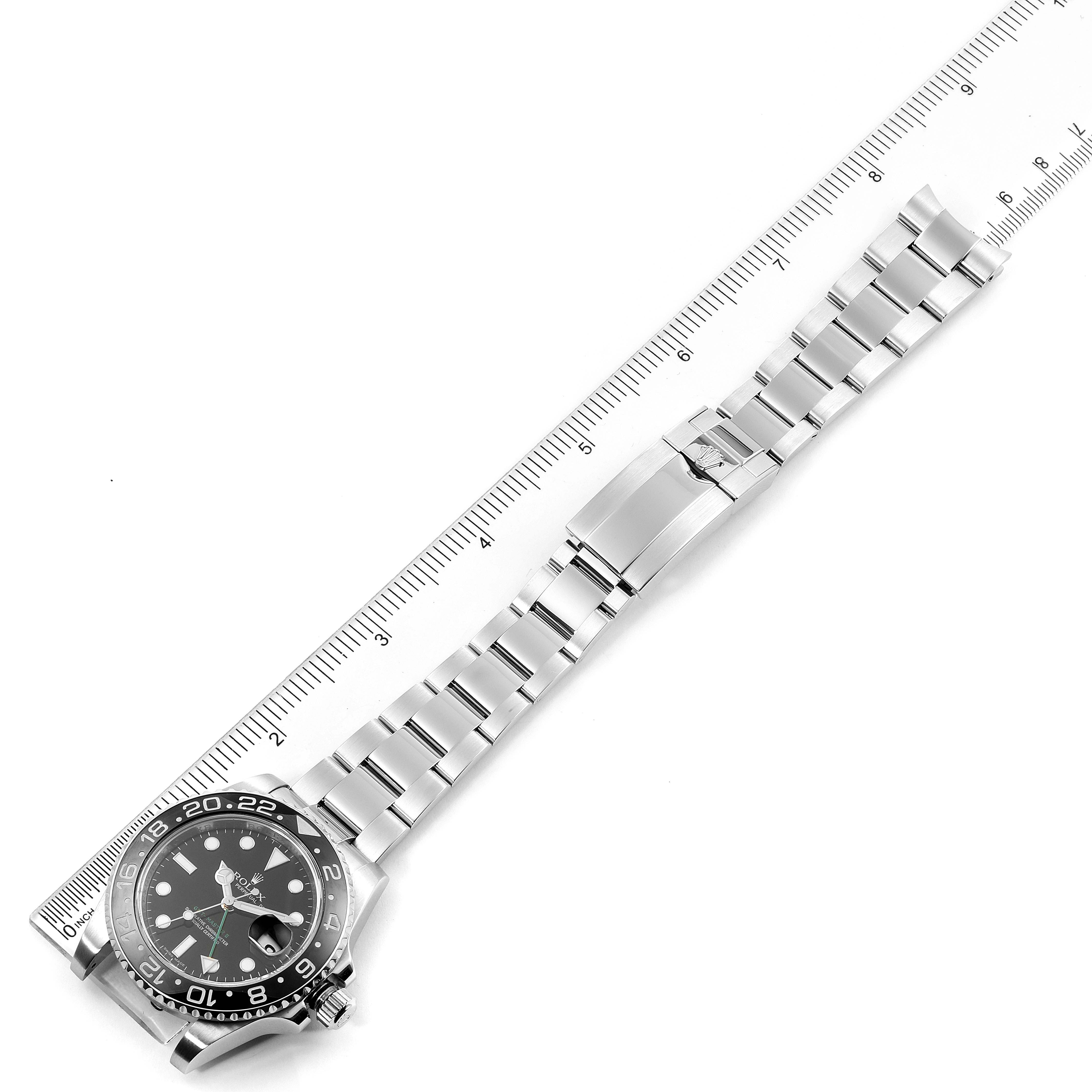 The image shows a top-down view of a Rolex GMT-Master 116710 Men
s Stainless Steel Black Dial 116710 Men
s Stainless Steel Black Dial watch alongside a ruler, highlighting the face and bracelet.