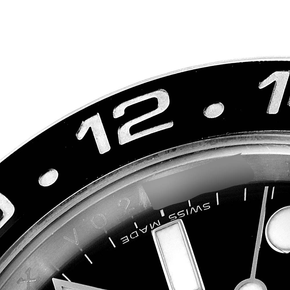 This close-up image of the Rolex GMT-Master 116710 Men
s Stainless Steel Black Dial 116710 Men
s Stainless Steel Black Dial model shows the 
12
 marker and surrounding bezel.