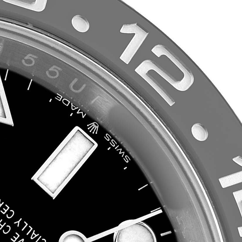 The image shows a close-up of the dial and bezel of a Rolex GMT-Master 126710GRNR Men's Stainless Steel Black Dial, highlighting the 12-hour marker and crown logo.