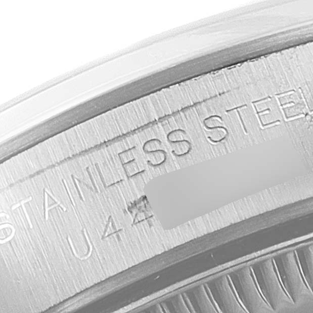 This close-up image shows the engraved side of a Rolex Oyster Perpetual 67180 Women's Stainless Steel Black Dial 67180 Women's Stainless Steel Black Dial watch, highlighting the "STAINLESS STEEL" inscription.
