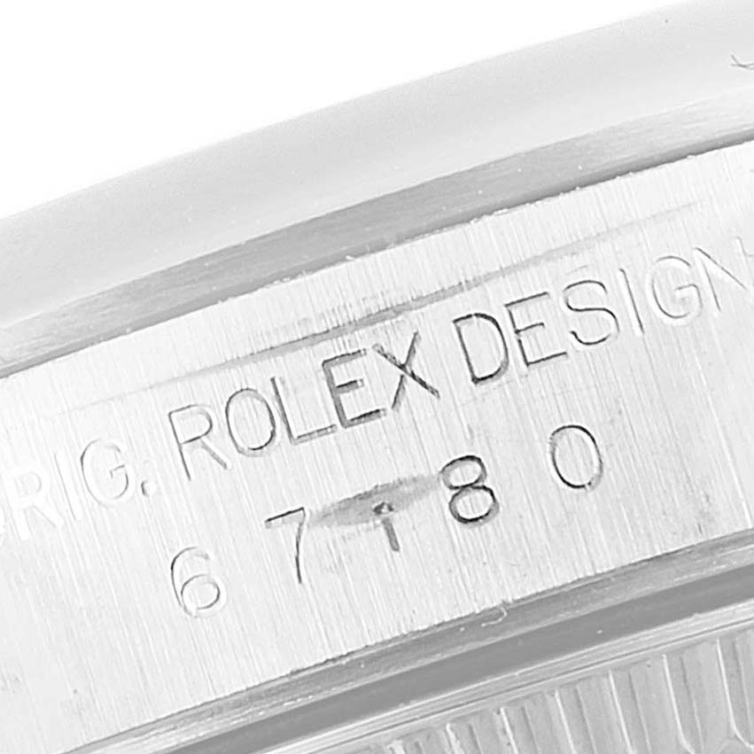 This image shows an angled close-up of the serial engraving on the case side of a Rolex Oyster Perpetual 67180 Women's Stainless Steel Black Dial 67180 Women's Stainless Steel Black Dial watch.