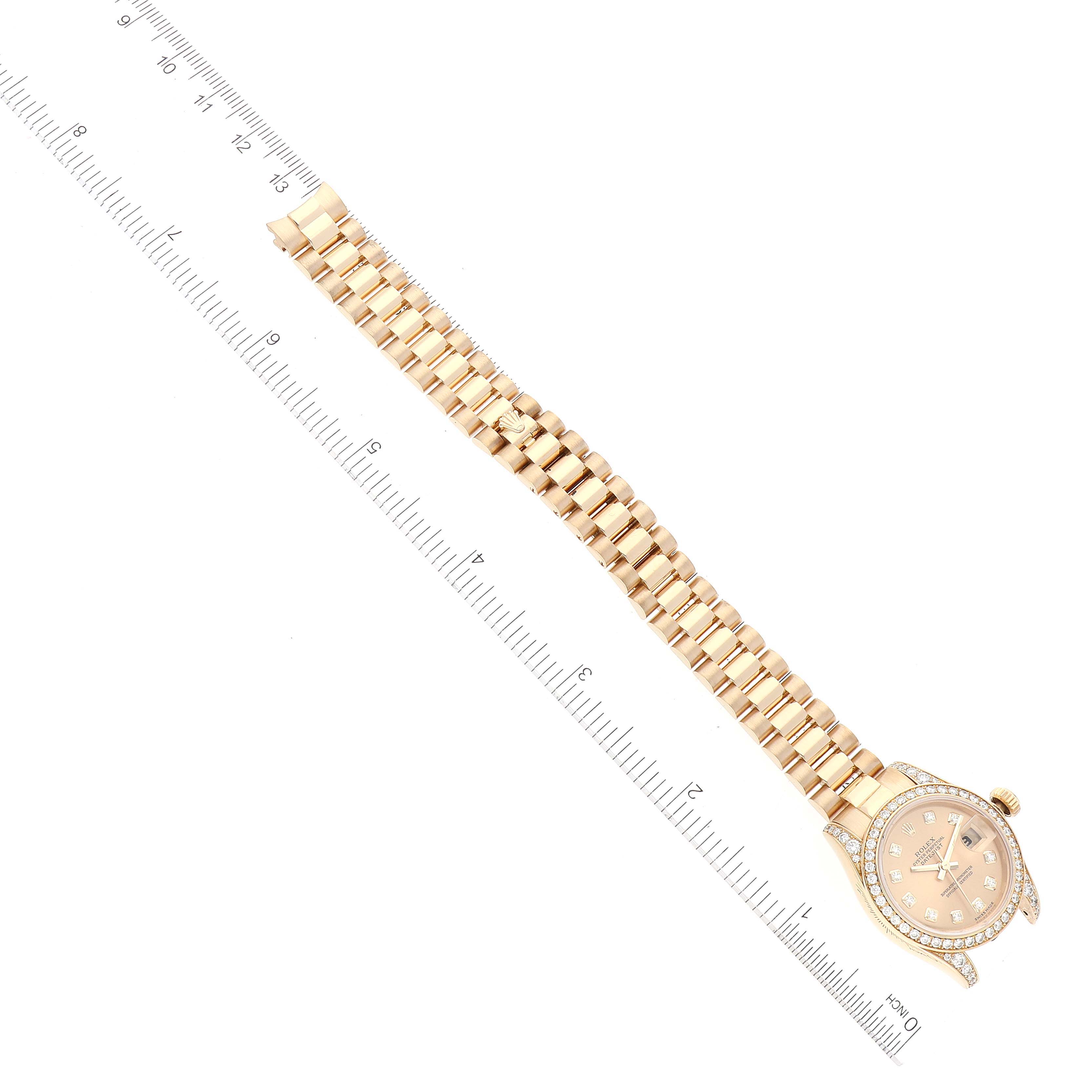 The image shows a Rolex President 179158 Women
s Yellow Gold Champagne Dial 179158 Women
s Yellow Gold Champagne Dial model watch laid flat, showcasing its gold bracelet, watch face, and a portion of a ruler for scale.