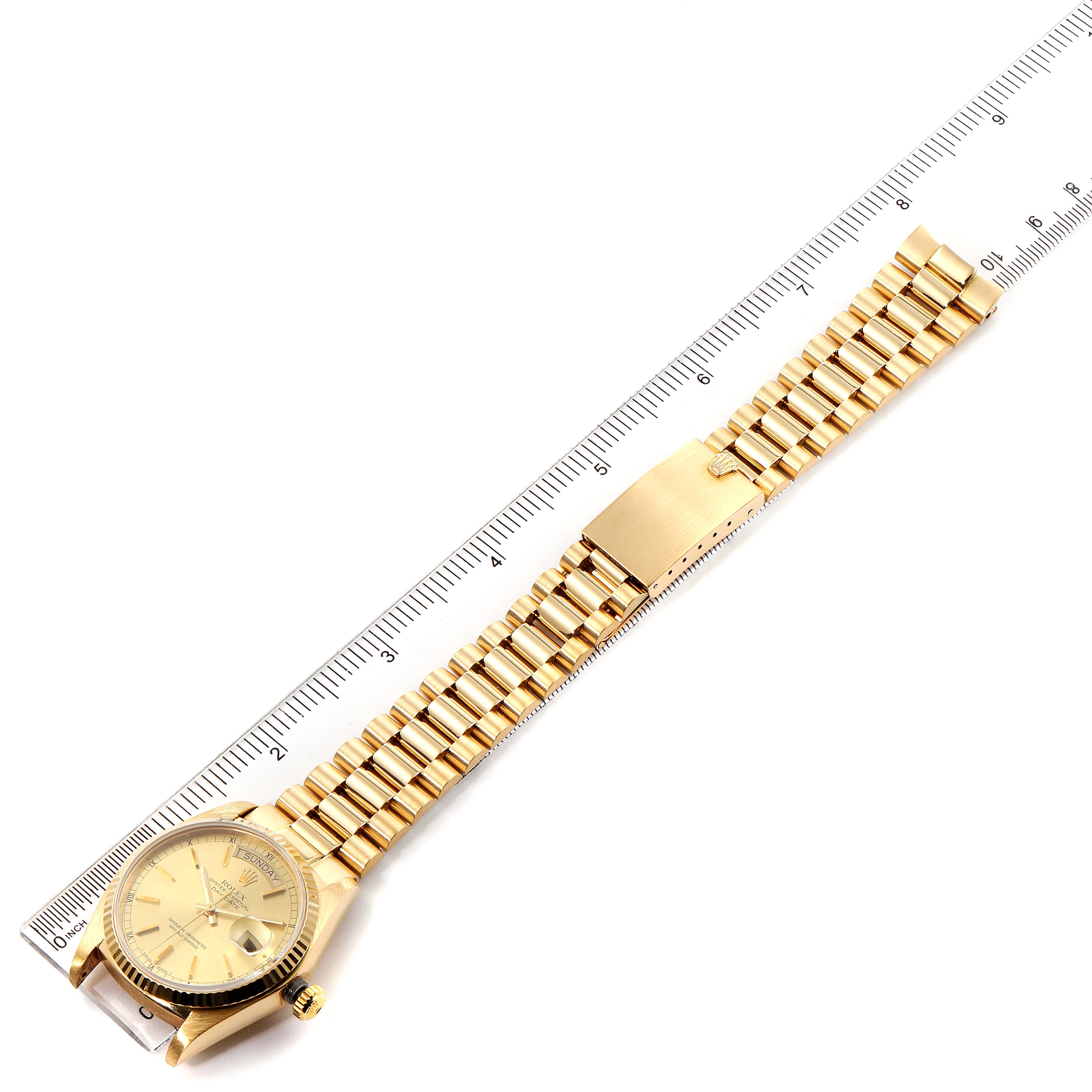 This image shows a full view from above of a Rolex President 18038 Men
s Yellow Gold Champagne Dial 18038 Men
s Yellow Gold Champagne Dial model watch next to a ruler.