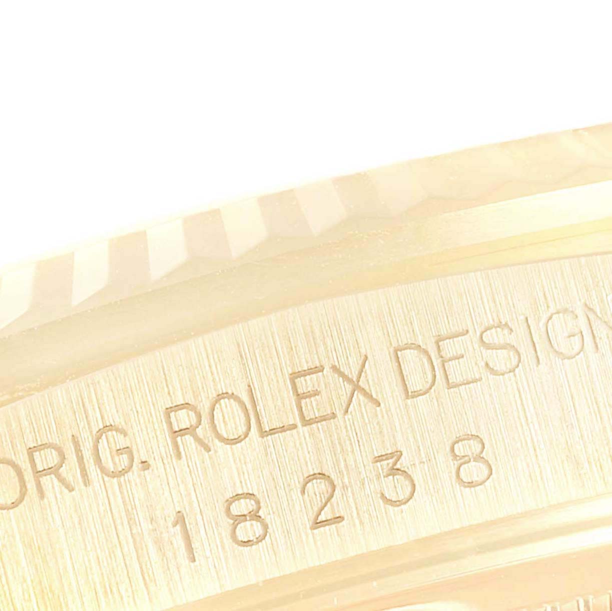 This close-up image shows the side of the Rolex President 18238 Men's Yellow Gold Champagne Dial 18238 Men's Yellow Gold Champagne Dial model, focusing on the engraving of the model number and "Rolex Design".