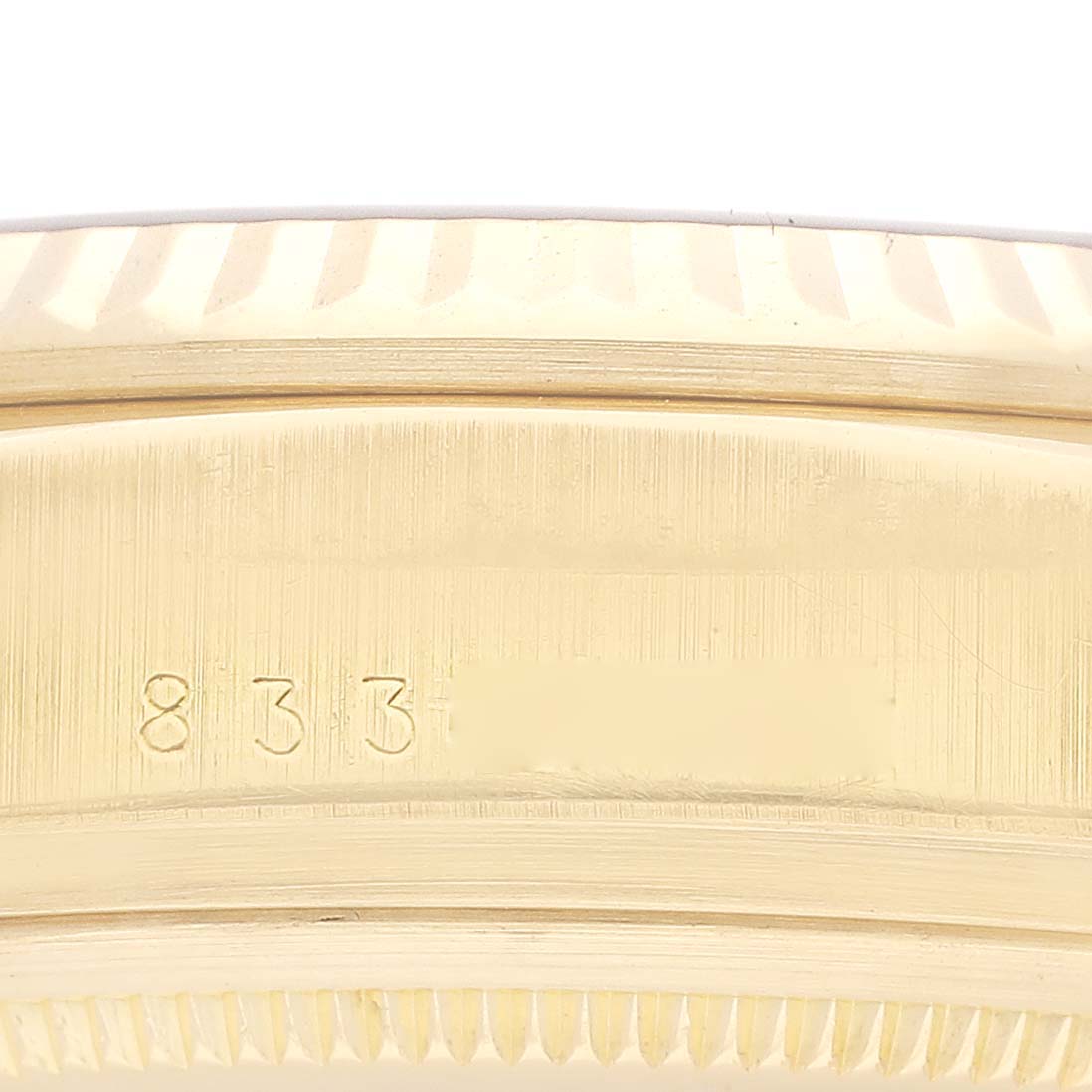 The image shows a close-up of the side of the case of a Rolex President 18038 Men's Yellow Gold Champagne Dial 18038 Men's Yellow Gold Champagne Dial watch, highlighting its serial number engraving.