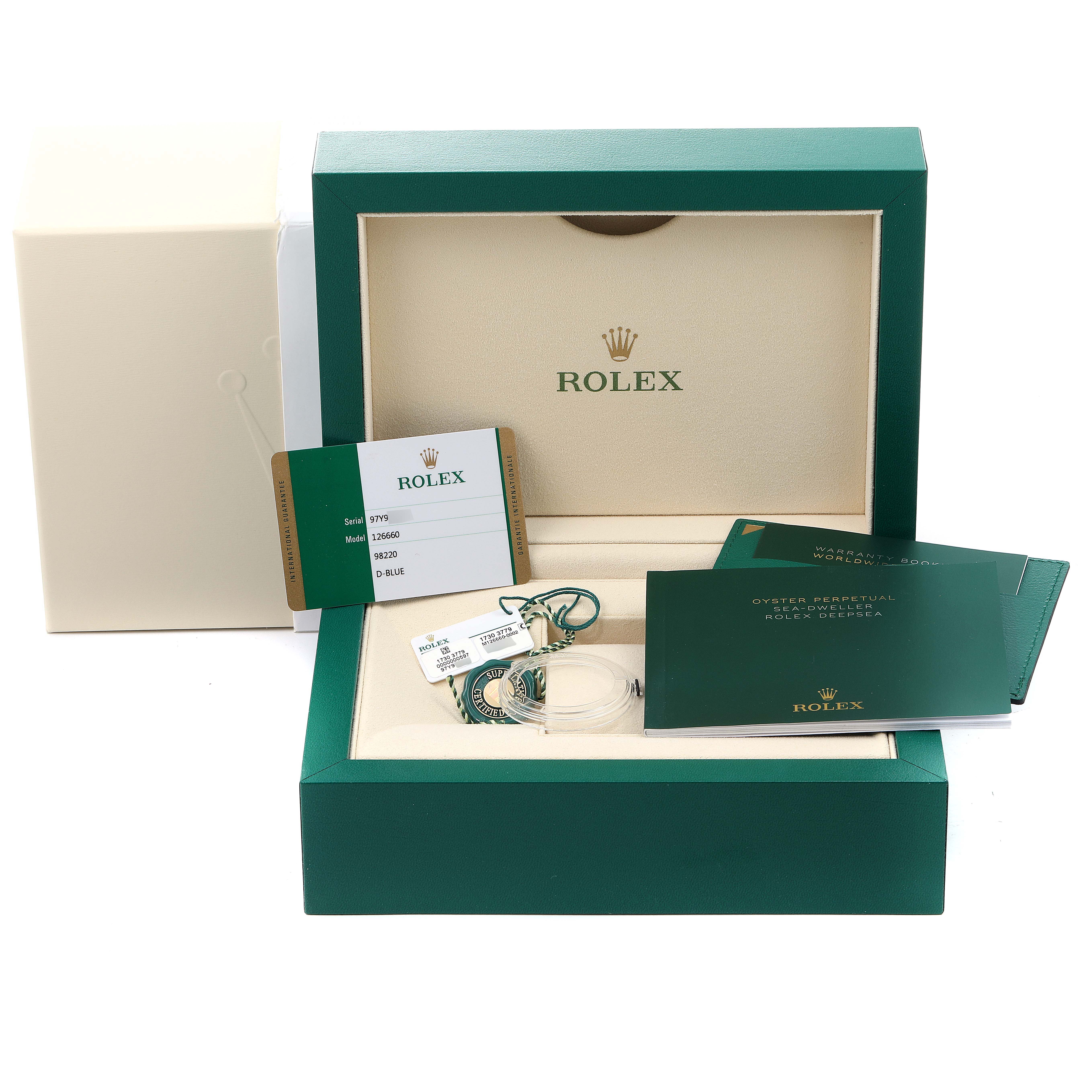 The image shows the open packaging and accompanying accessories for a Rolex Sea-Dweller 126660 Men's Stainless Steel Blue Dial 126660 Men's Stainless Steel Blue Dial watch.