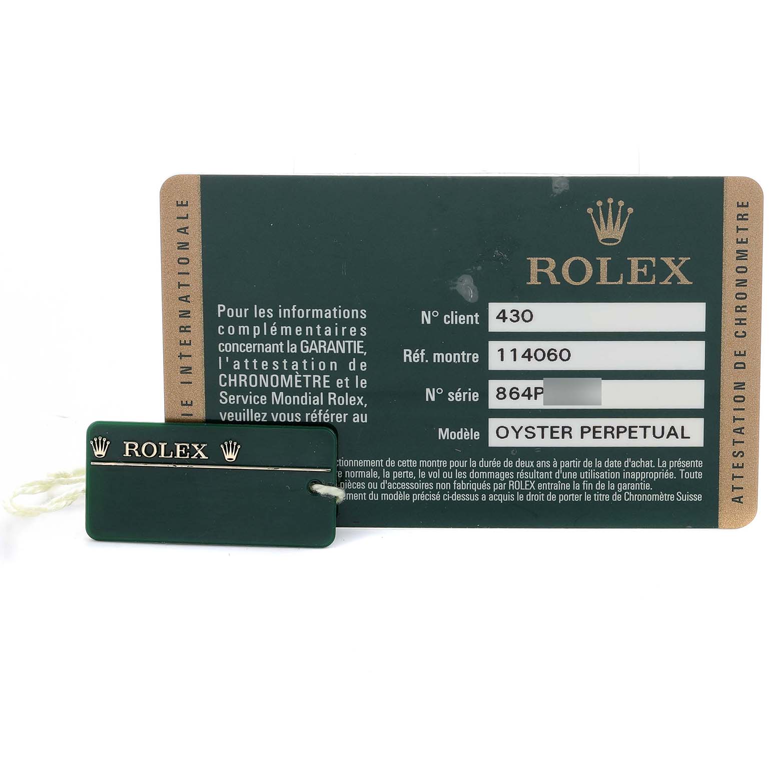 The image shows a Rolex Submariner 114060 Men's Stainless Steel Black Dial's warranty card and tag in a top-down view.
