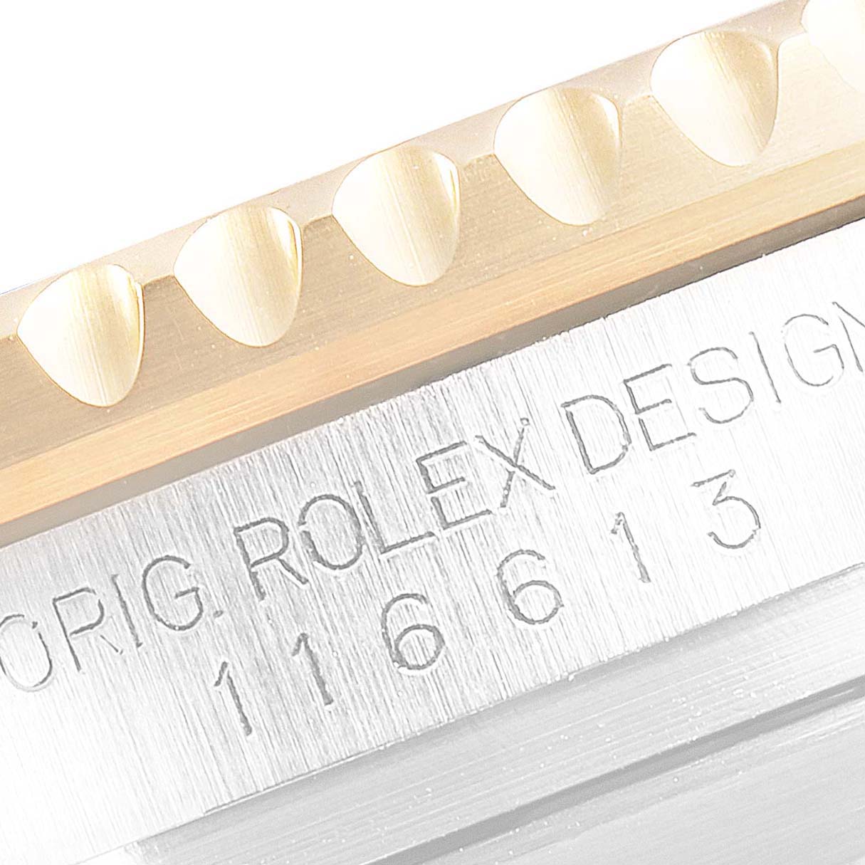 The image shows a close-up of the Rolex Submariner 116613 Men's Steel and Gold (two tone) Blue Dial 116613 Men's Steel and Gold (two tone) Blue Dial's bezel and part of the engraved caseback.