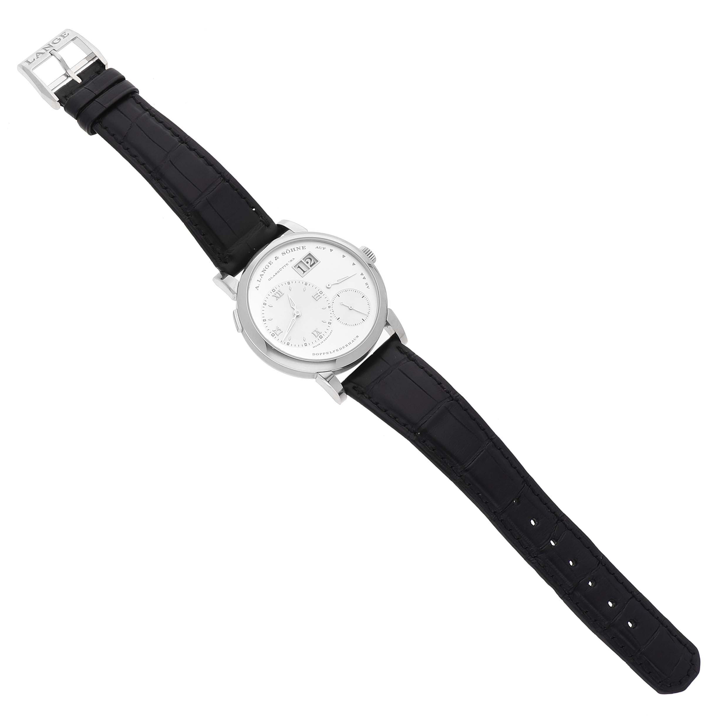 The A. Lange 
Sohne Lange 1 191.039 Men
s White Gold Silver Dial watch is shown from a top-down angle, displaying the face and full black leather strap.