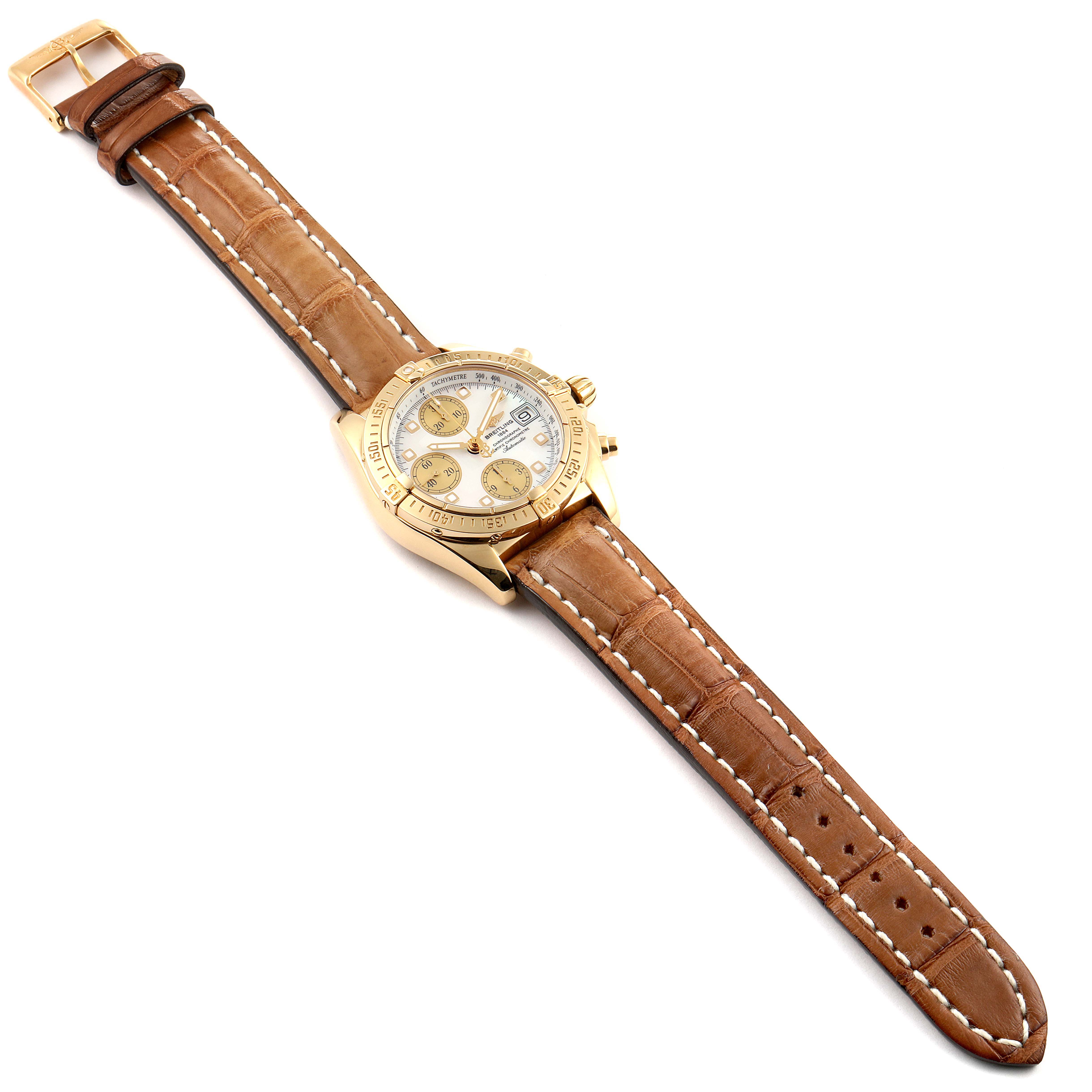 The Breitling Chronomat K13358 Men's Yellow Gold Mother of Pearl Dial K13358 Men's Yellow Gold Mother of Pearl Dial watch is shown at a top-view angle, displaying the entire face, bezel, case, and leather strap.