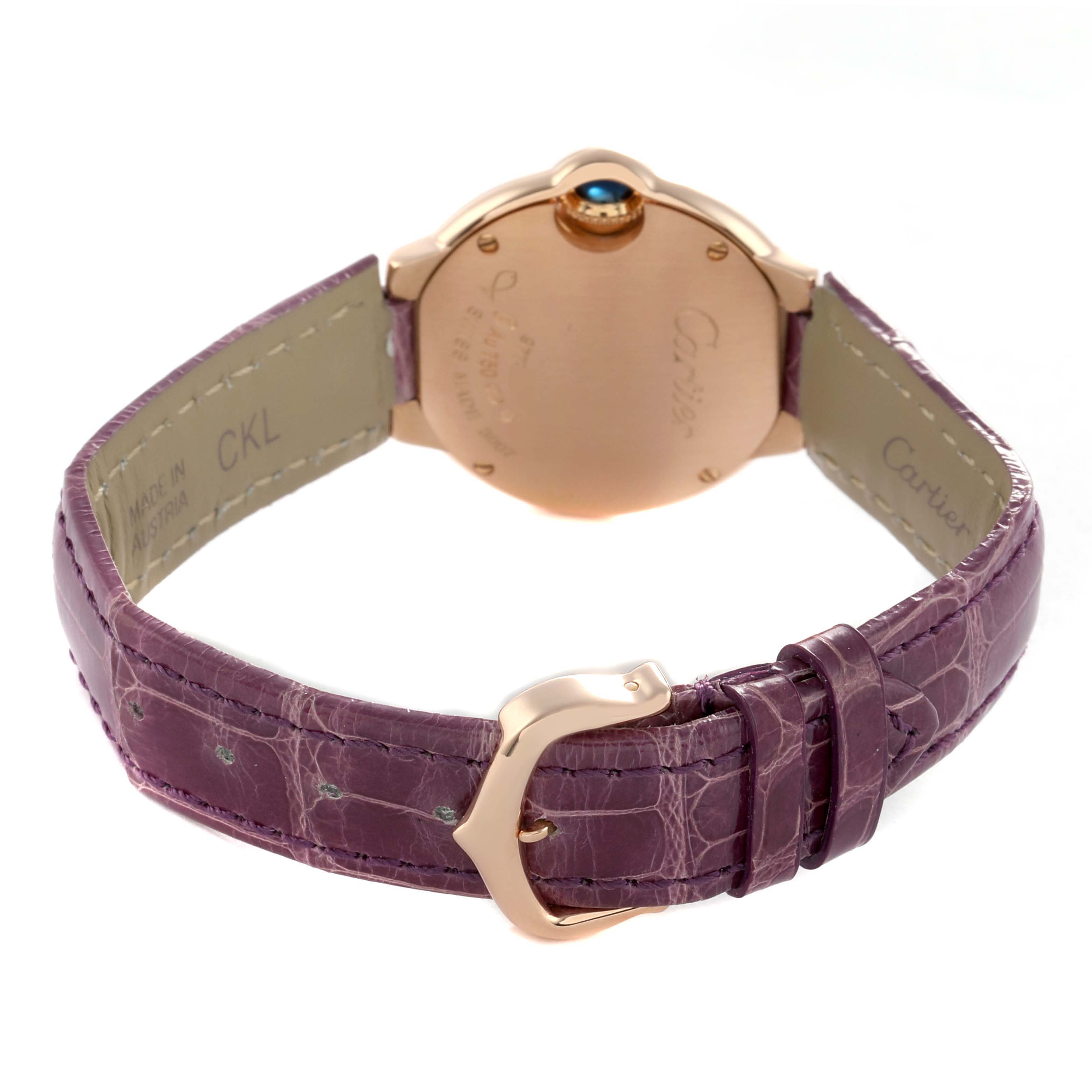The Cartier Ballon Bleu W6900256 Women's Rose Gold Silver Dial watch is shown from the back, highlighting the case, crown, and purple alligator strap with a buckle.