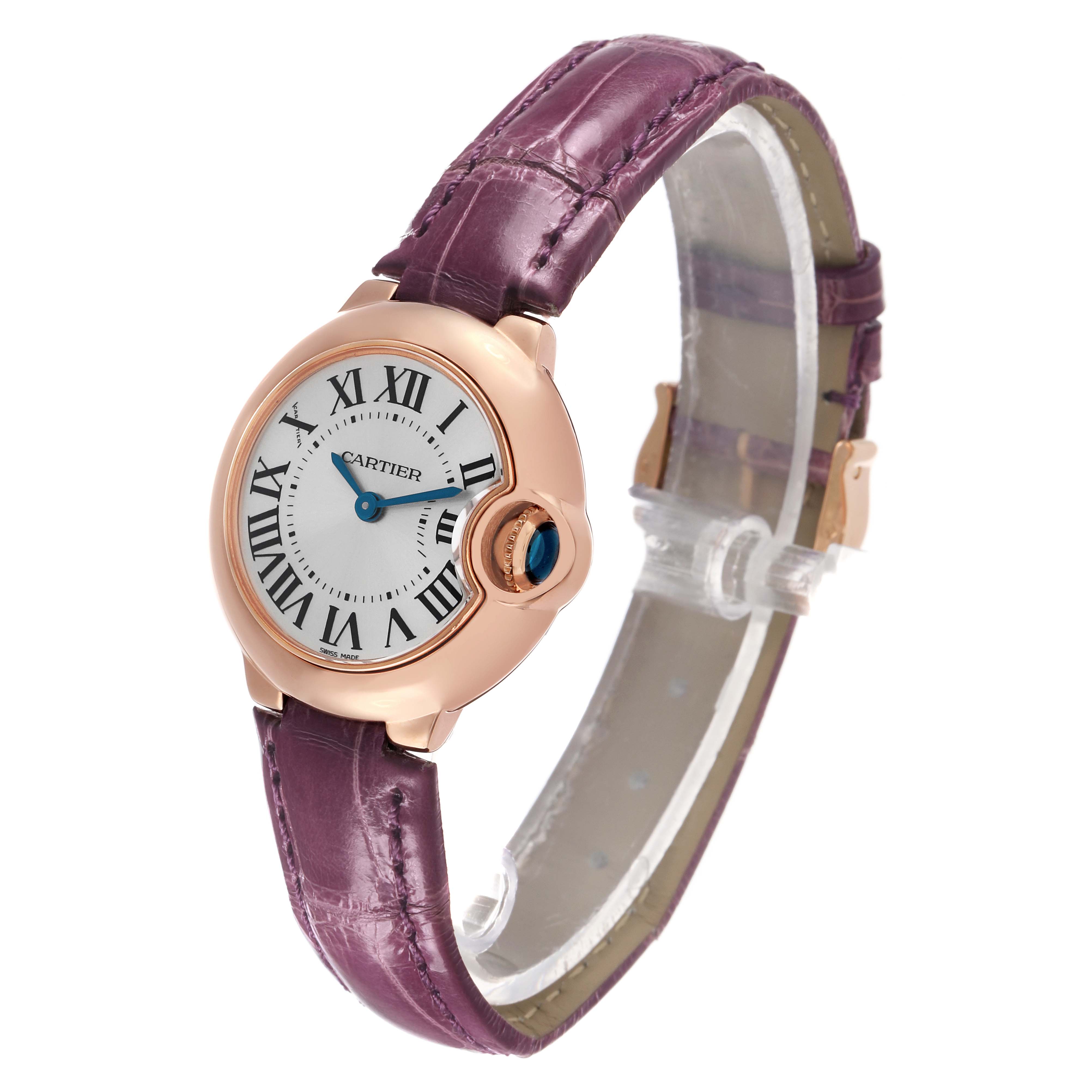 The Ballon Bleu de Cartier watch is shown at a three-quarter angle, highlighting the face, roman numerals, crown, and purple strap.