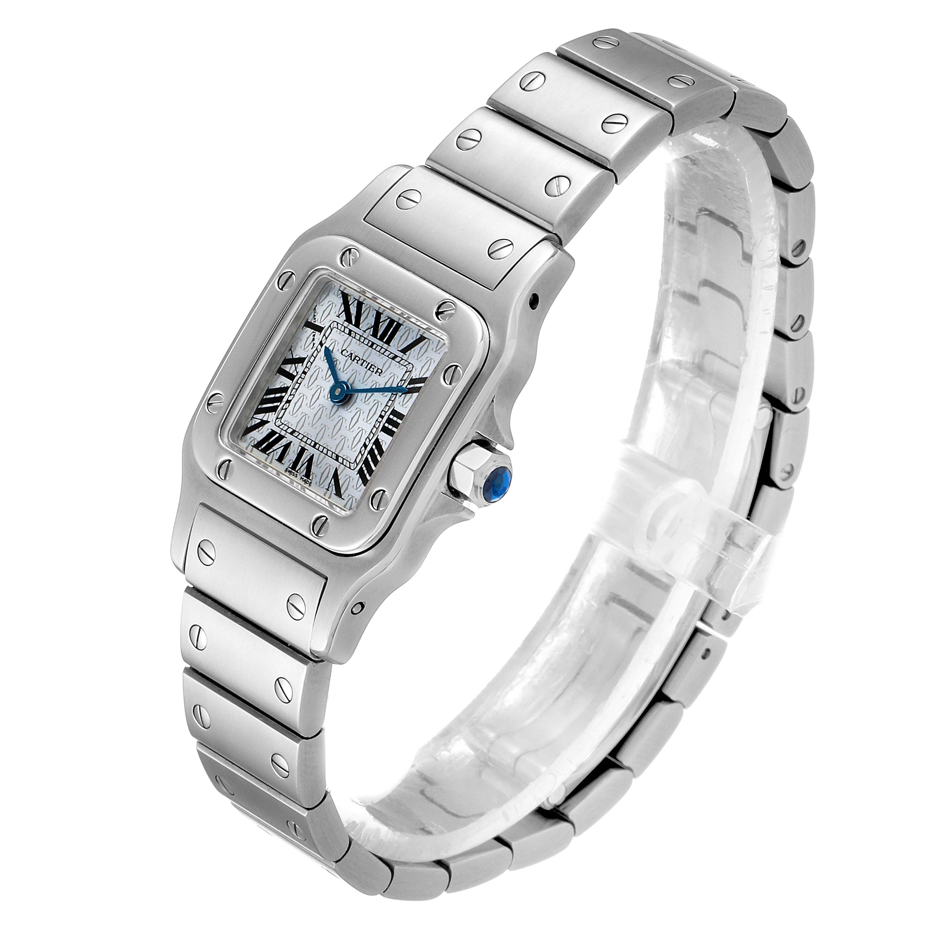This image shows a Cartier Santos W20064D6 Women's Stainless Steel Blue Dial W20064D6 Women's Stainless Steel Blue Dial watch at a three-quarter angle, highlighting its face, bezel, bracelet, and crown with a blue cabochon.