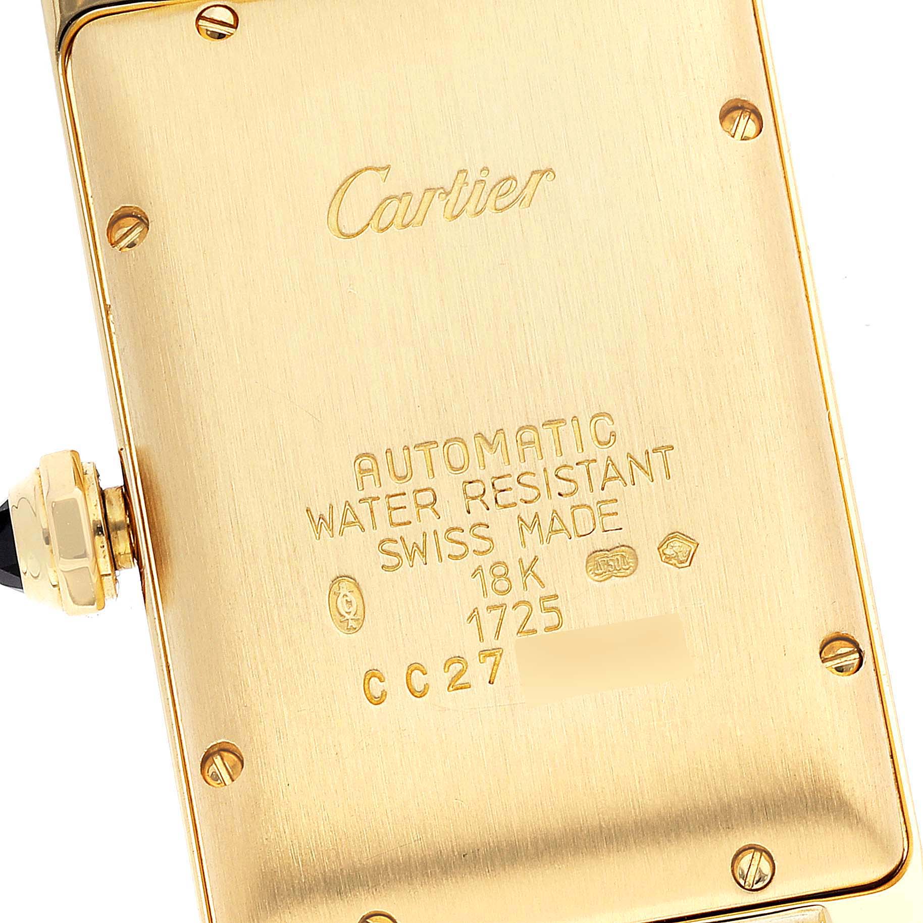 The image shows the back case of a Cartier Tank Americaine W26035K2 Women's Yellow Gold Silver Dial W26035K2 Women's Yellow Gold Silver Dial watch, highlighting the engravings and crown from a close-up angle.
