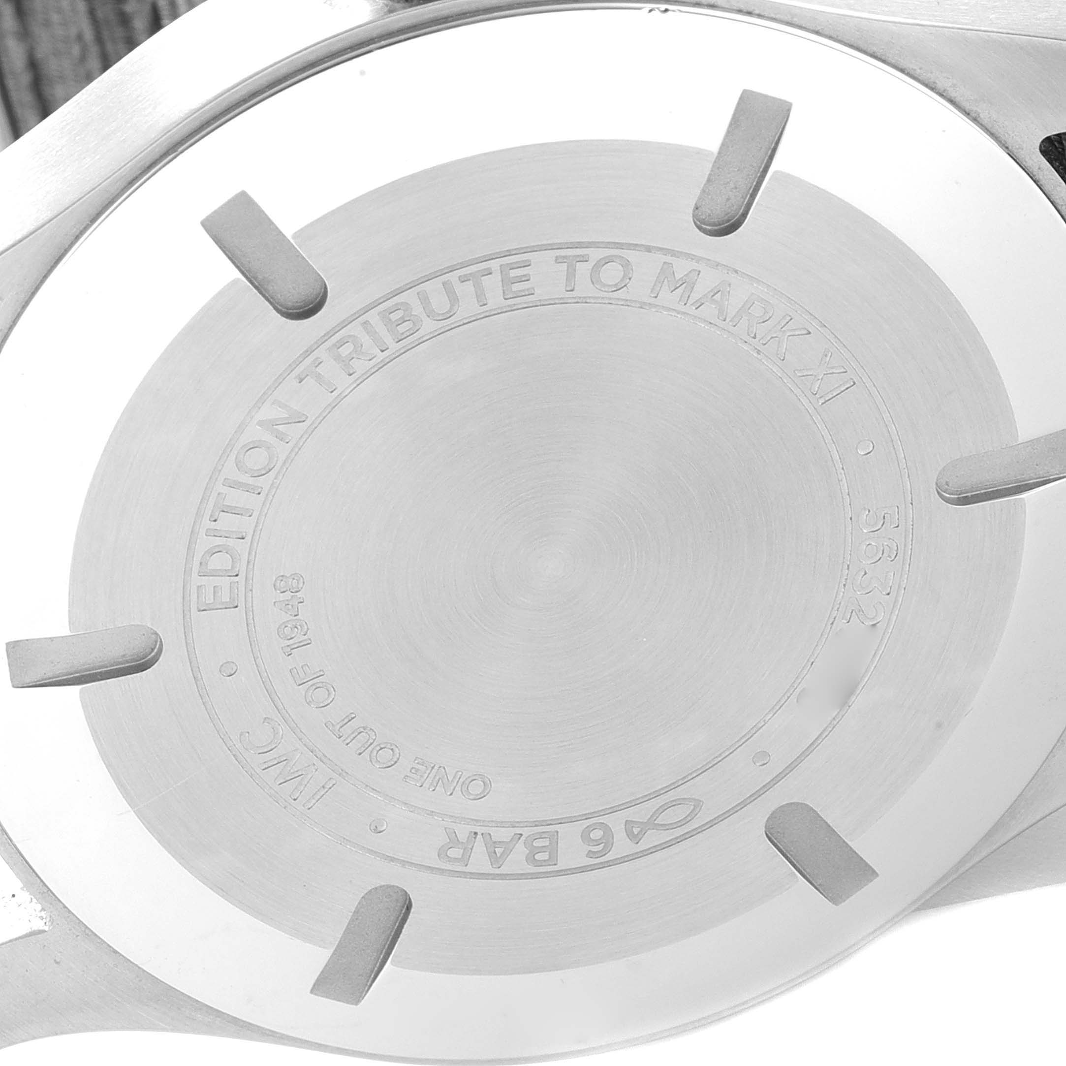 Close-up of the case back of an IWC Pilot IW327007 Men's Stainless Steel Black Dial IW327007 Men's Stainless Steel Black Dial model "Edition Tribute to Mark XI" watch, showing engravings and attachment points.