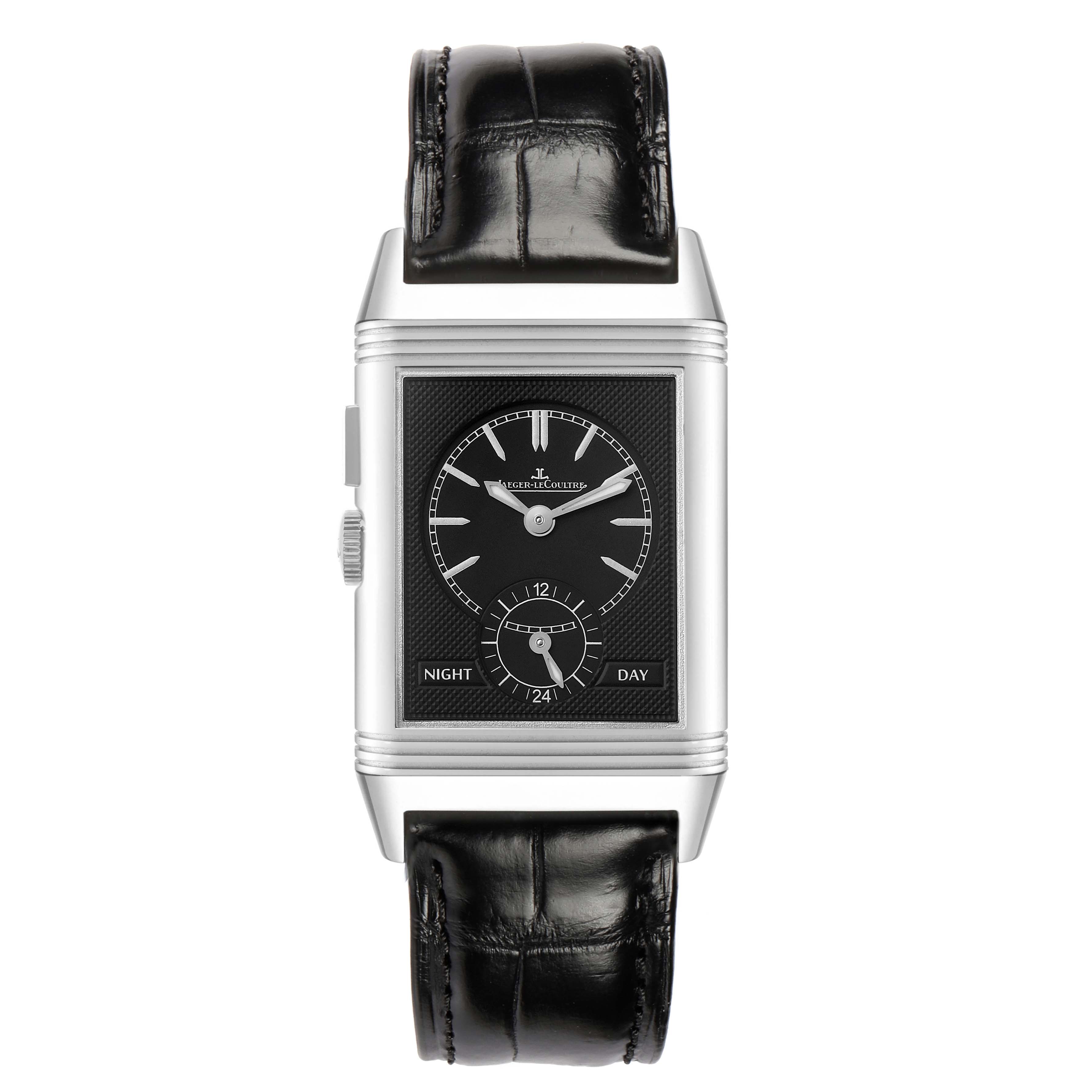 The Jaeger-LeCoultre Reverso watch is shown from the front, highlighting its black dial, silver case, and leather strap.