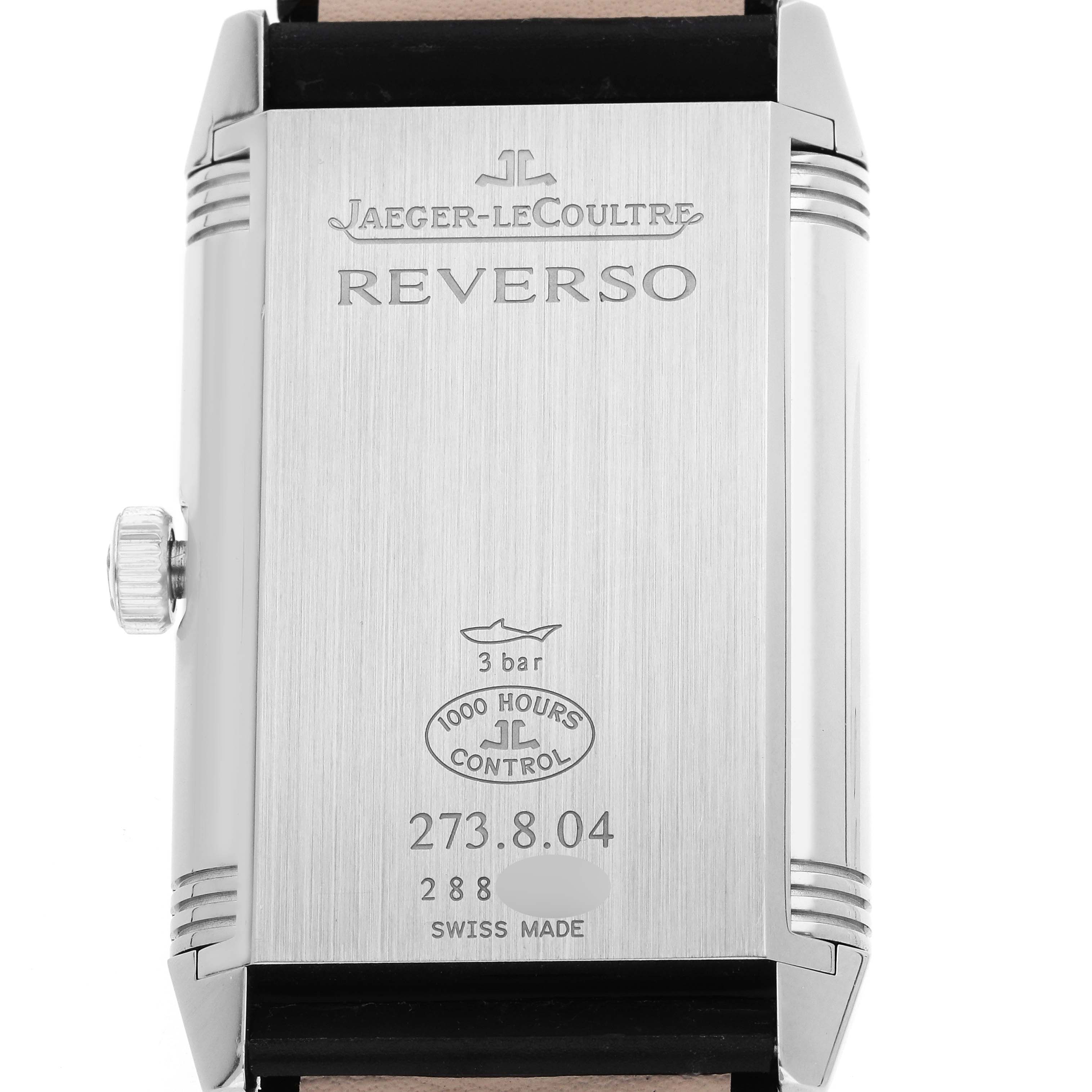 The image shows the back of the Jaeger-LeCoultre Reverso watch, displaying engravings, a crown, and case details.