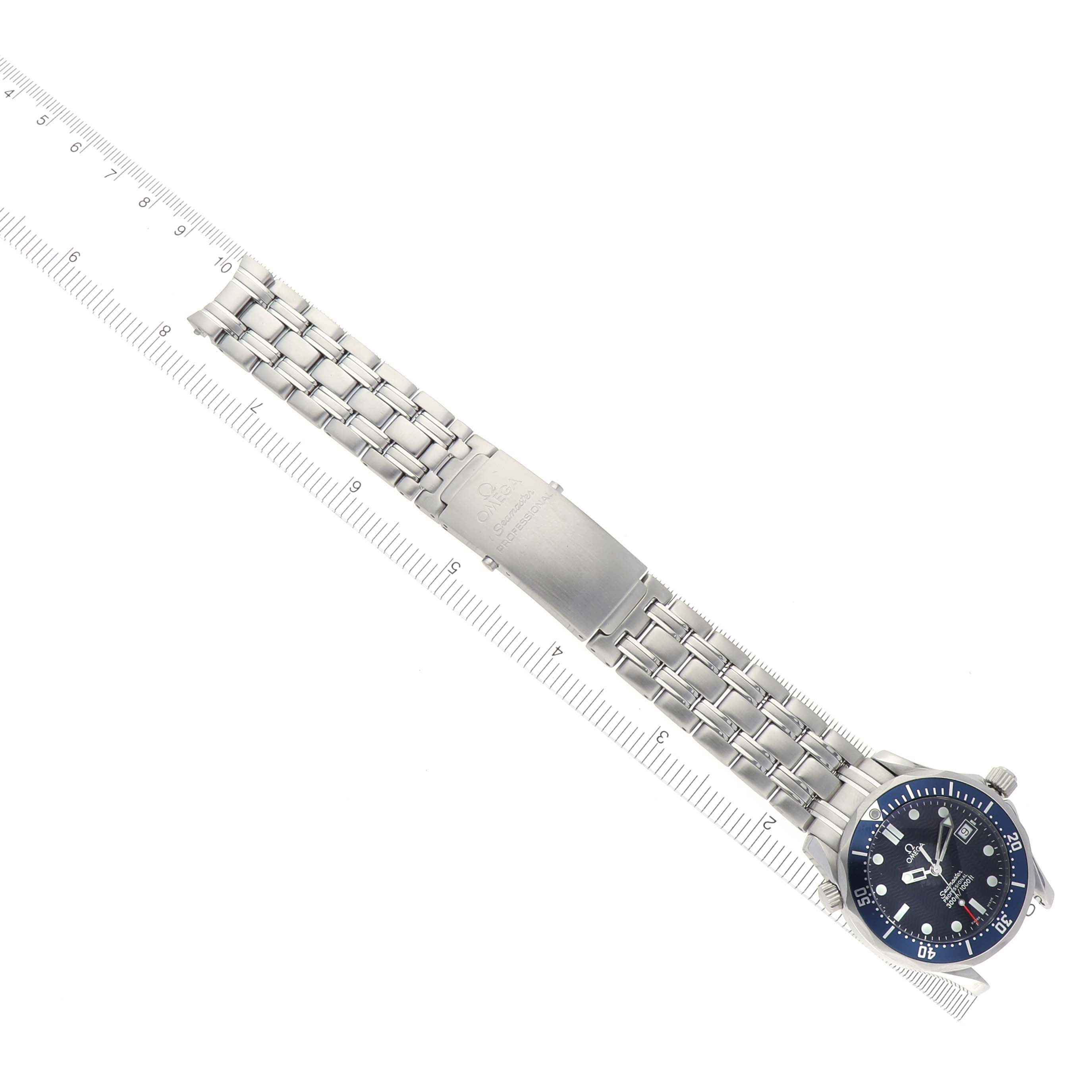 The image shows an Omega Seamaster 2561.80.00 Men's Stainless Steel Blue Dial 2561.80.00 Men's Stainless Steel Blue Dial watch from a top-down angle, displaying the face, bracelet, and deployment clasp next to a ruler.