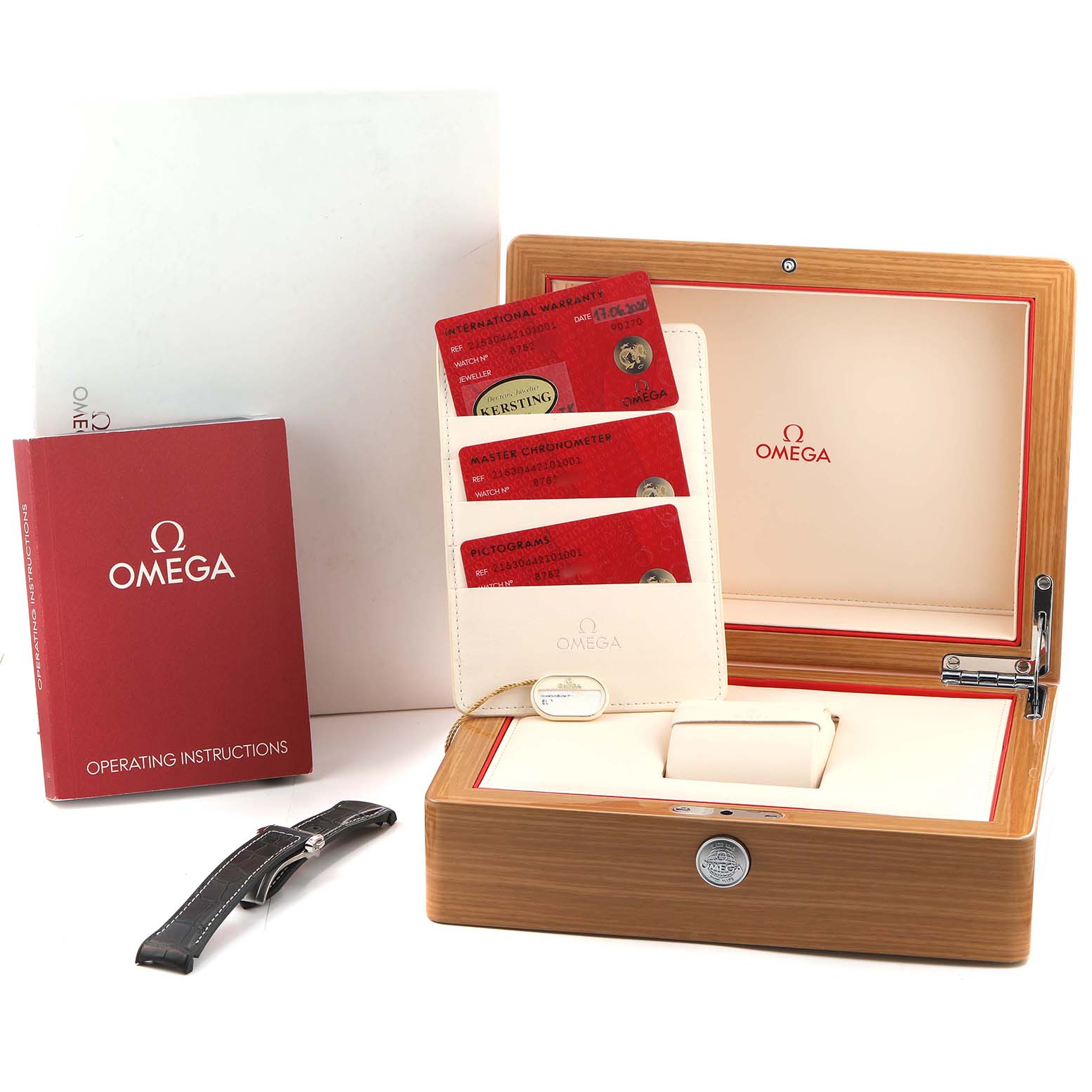 The image shows the Omega Planet Ocean 215.30.44.21.01.001 Men's Stainless Steel Black Dial watch box, warranty cards, operating instructions, and an extra strap.