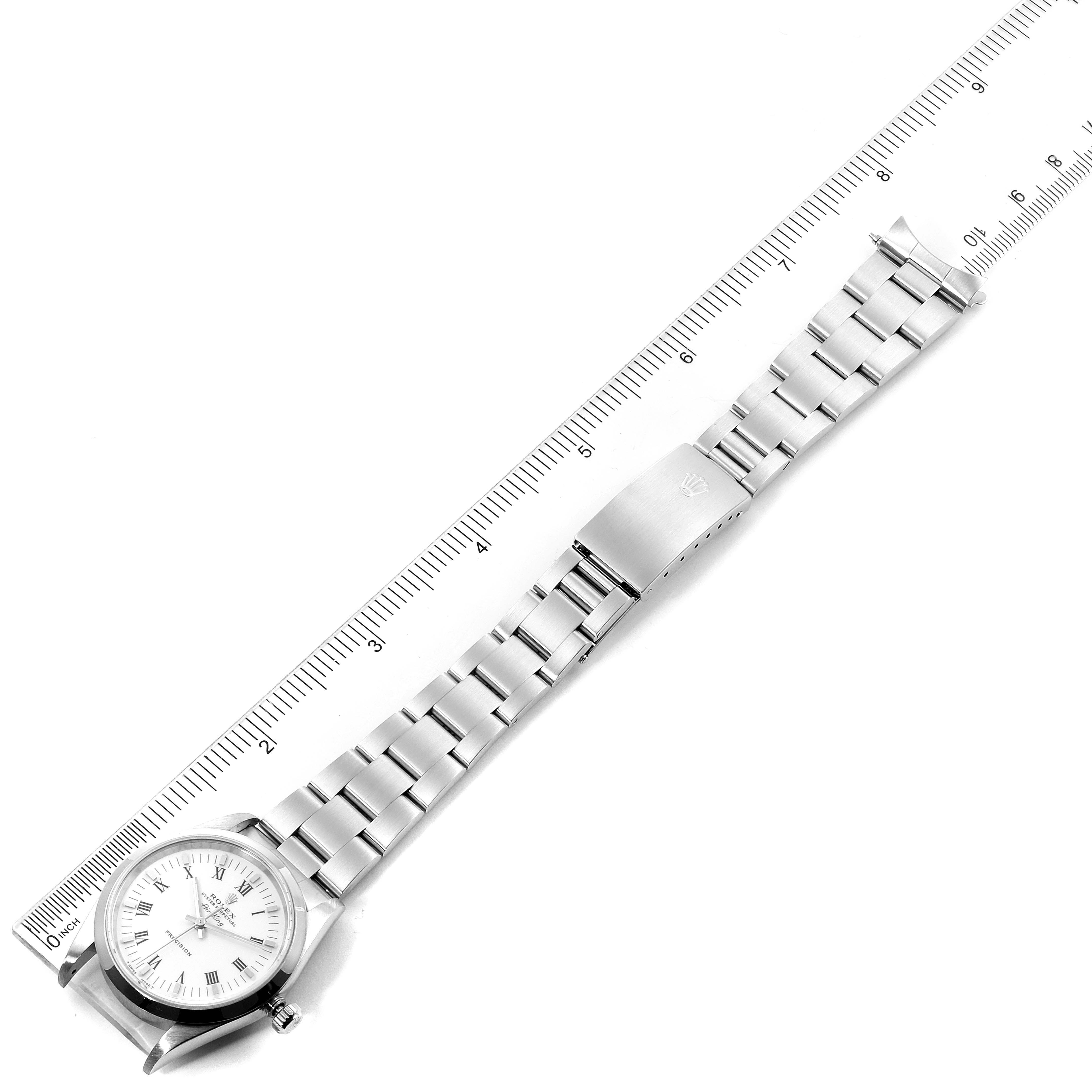 This image shows a top-down view of the Rolex Air-King 14000 Men's Stainless Steel White Dial 14000 Men's Stainless Steel White Dial watch, including its face, links, and clasp, beside a ruler for scale.