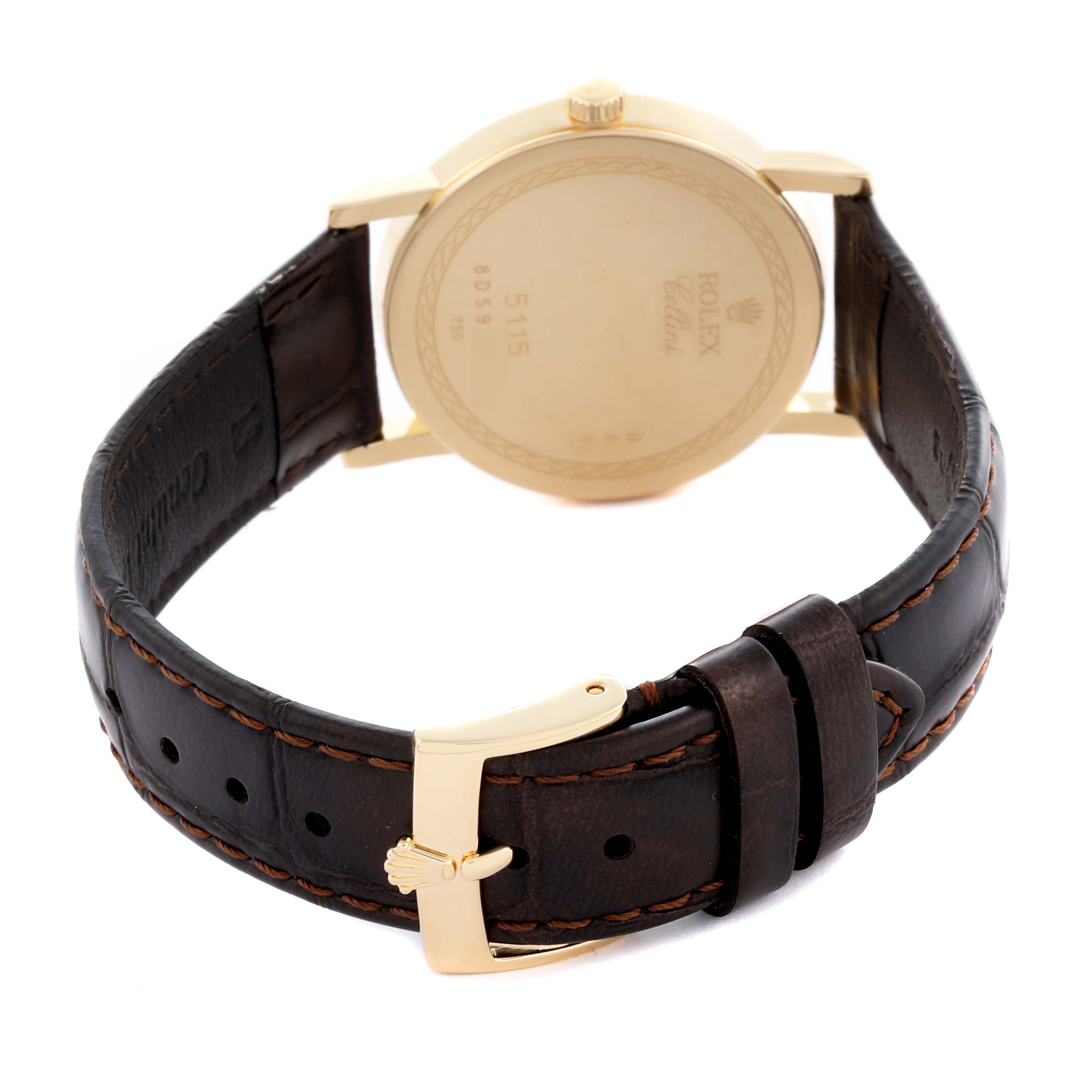 The image shows the back case and clasp of a Rolex Cellini 5115/8 Men's Yellow Gold White Dial 5115/8 Men's Yellow Gold White Dial watch, angled to display the leather strap and gold-tone buckle.