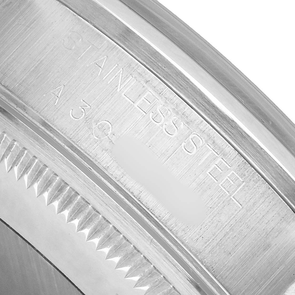 The image shows a close-up of the stainless steel bezel and part of the back of a Rolex Date 15200 Men's Stainless Steel Blue Dial watch.