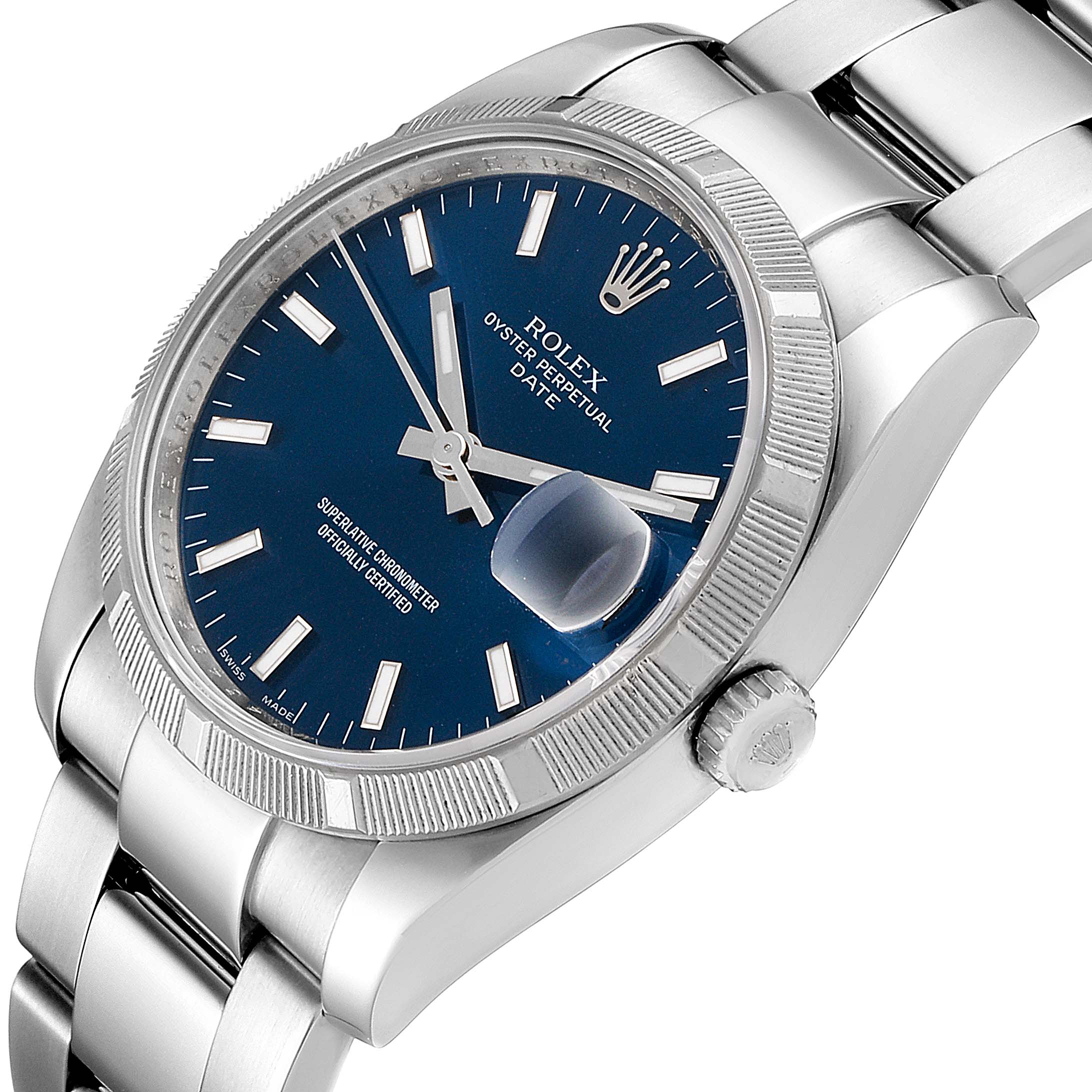 The image shows a close-up angle of a Rolex Date 115210 Men's Stainless Steel Blue Dial 115210 Men's Stainless Steel Blue Dial model watch, highlighting the blue dial, fluted bezel, and the crown.