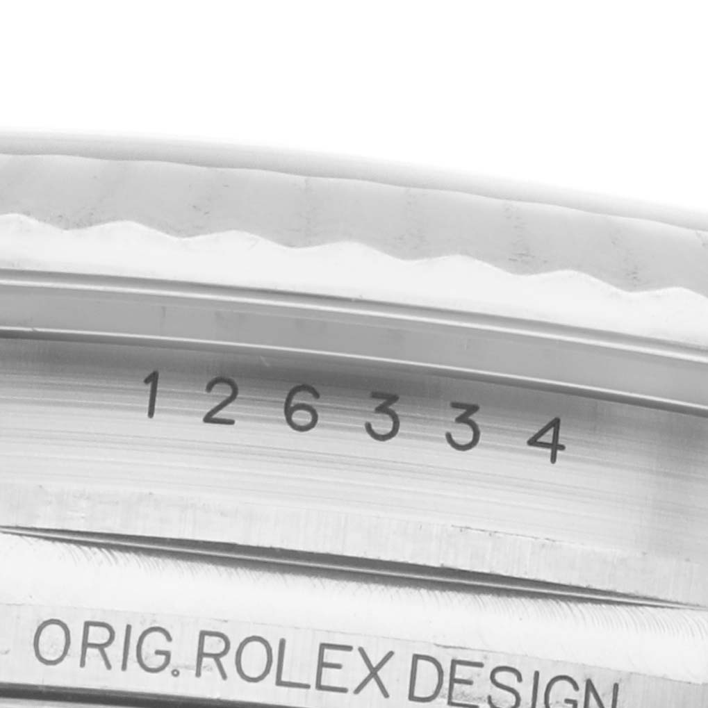 The image shows a close-up of the Rolex Datejust 41 126334 Men's Stainless Steel Blue Dial model's inner bezel with engravings, including part of the serial number and "ORIG. ROLEX DESIGN."