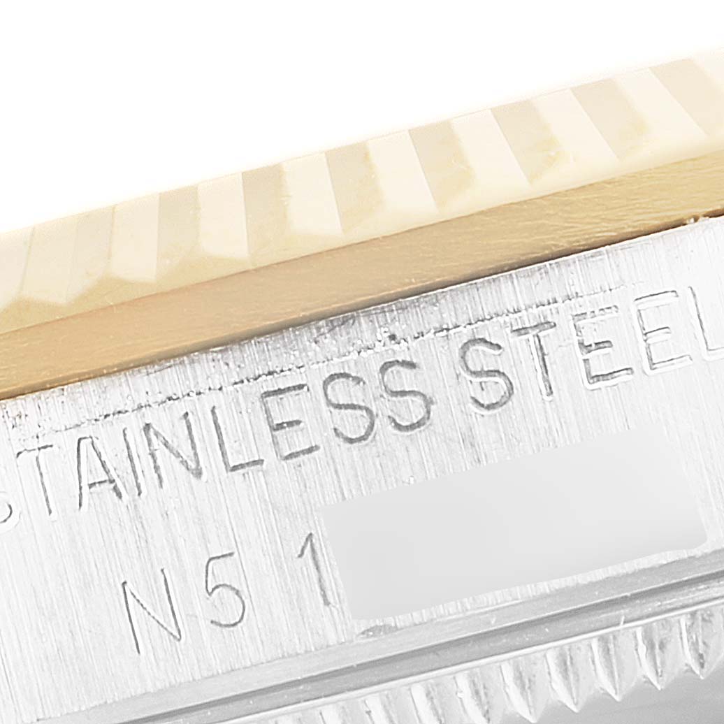 This close-up image of a Rolex Mid-Size 68273 Women's Steel and Gold (two tone) Champagne Dial 68273 Women's Steel and Gold (two tone) Champagne Dial watch shows its fluted bezel and engraved stainless steel case.