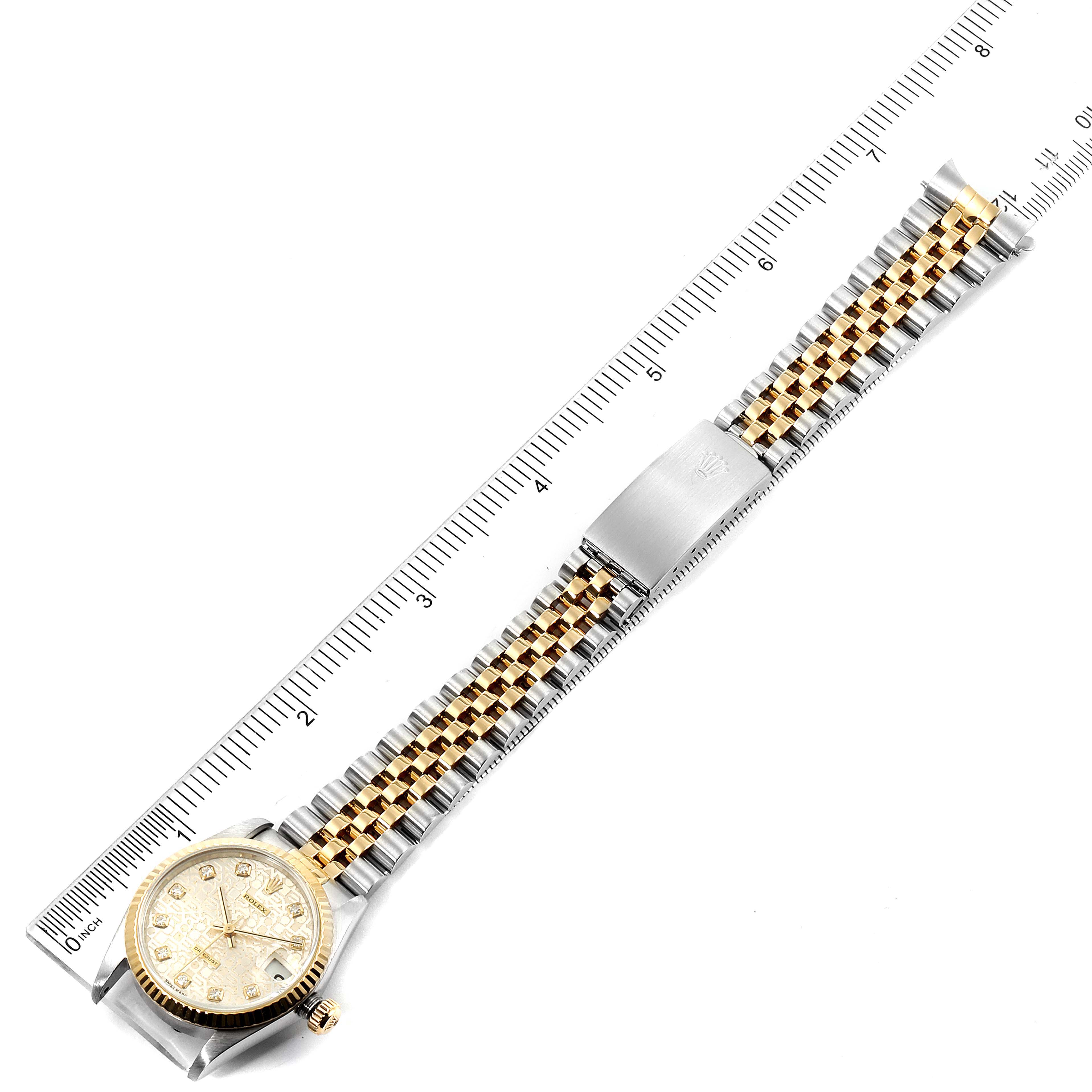 The Rolex Mid-Size 68273 Women's Steel and Gold (two tone) Silver Dial 68273 Women's Steel and Gold (two tone) Silver Dial watch is shown from an overhead angle, displaying the face, bezel, and full bracelet against a ruler for scale.