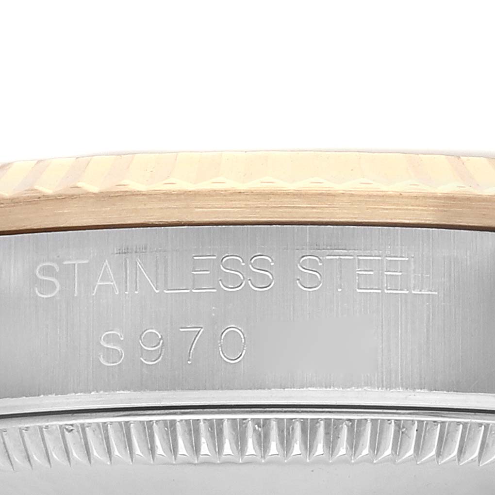 This image shows a close-up of the engraved inner bezel of the Rolex Mid-Size 68273 Women
s Steel and Gold (two tone) White Dial 68273 Women
s Steel and Gold (two tone) White Dial model watch, indicating "STAINLESS STEEL" and a serial number.
