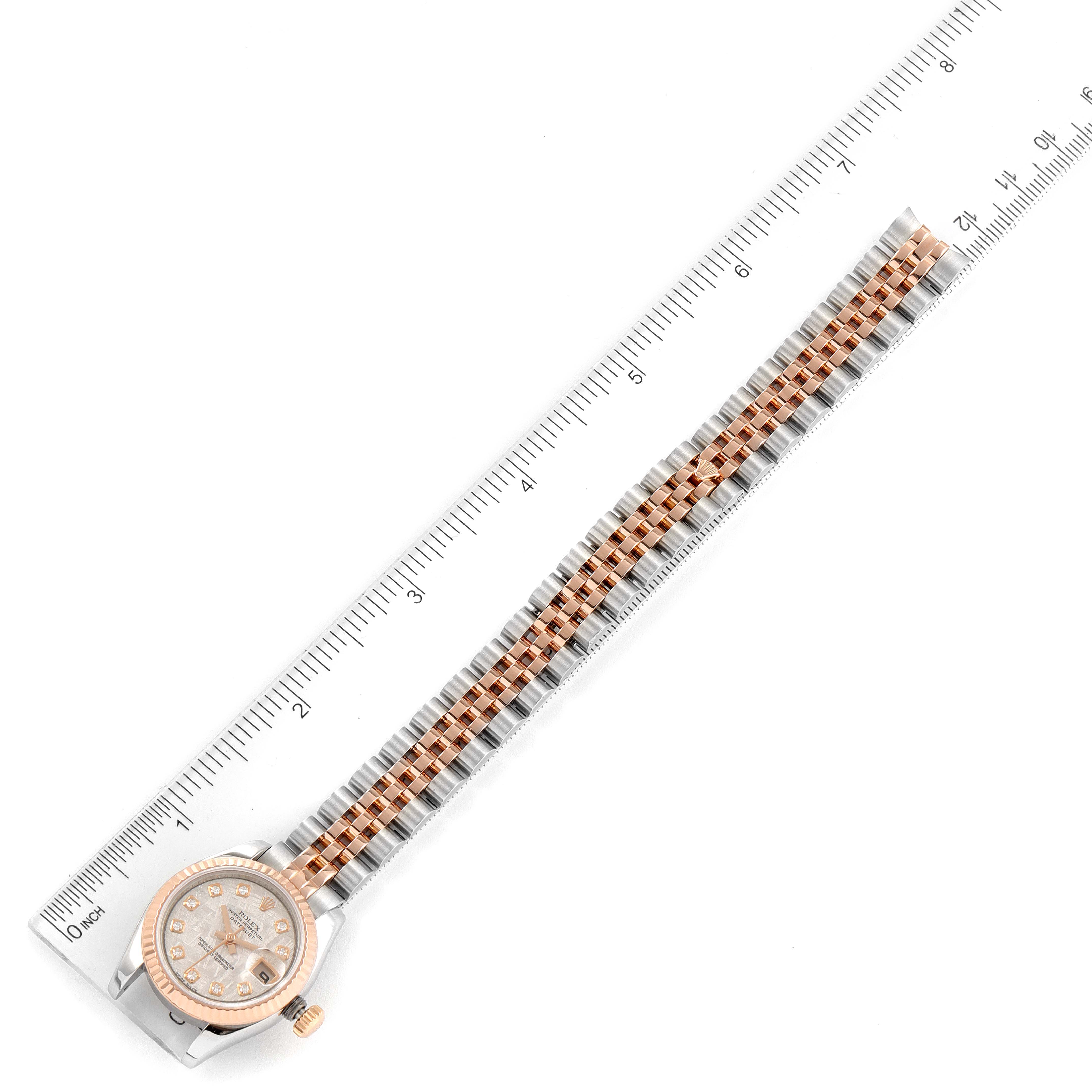 The image shows a Rolex Datejust 179171 Women
s Steel and Gold (two tone) Silver Dial 179171 Women
s Steel and Gold (two tone) Silver Dial watch laid flat with its band fully extended beside a ruler.