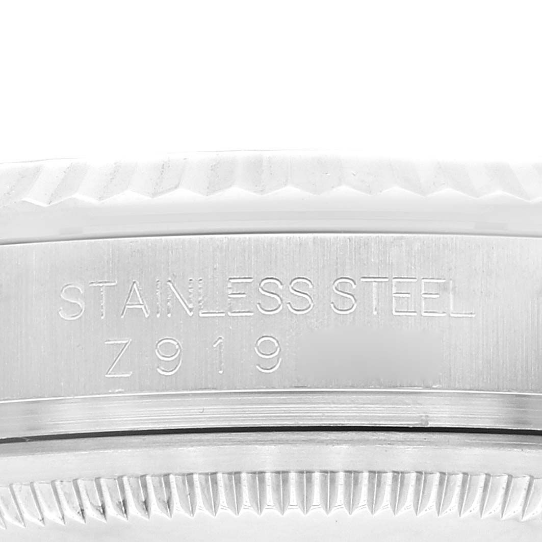 The image shows a close-up angle of the engravings on the side of the case of a Rolex Datejust 116234 Men's Stainless Steel Blue Dial 116234 Men's Stainless Steel Blue Dial watch, detailing its stainless steel material.
