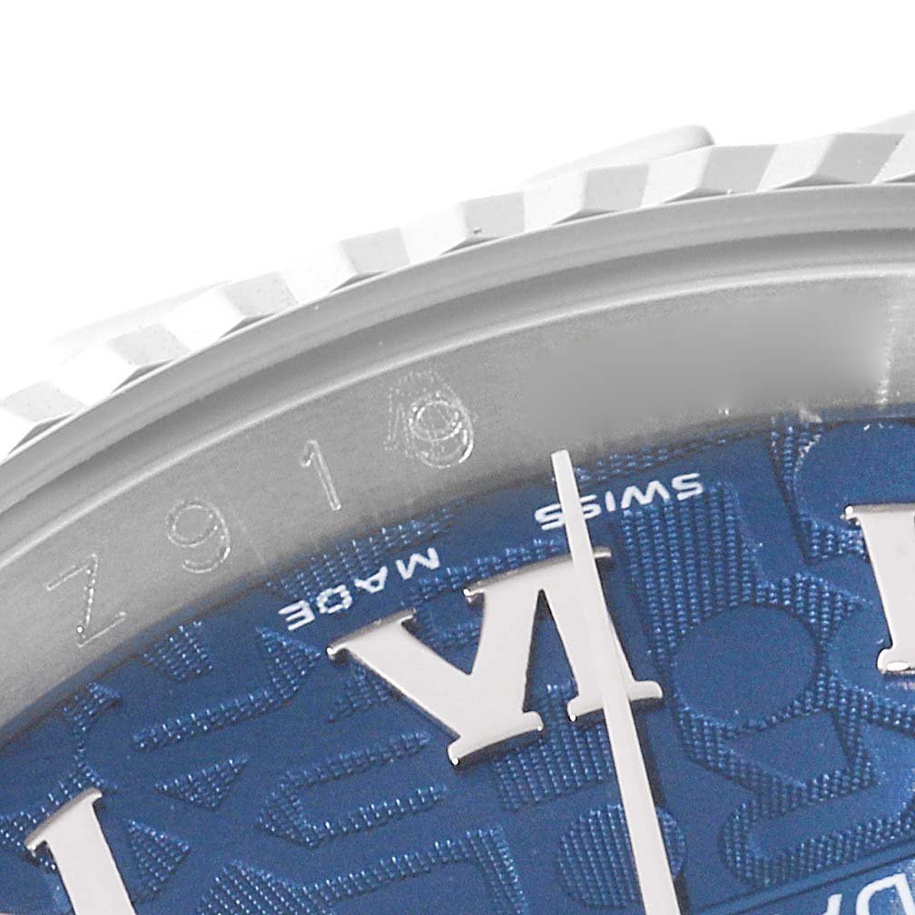 This close-up image of a Rolex Datejust 116234 Men's Stainless Steel Blue Dial 116234 Men's Stainless Steel Blue Dial watch displays the bezel, part of the dial, and a portion of the Roman numeral VI.