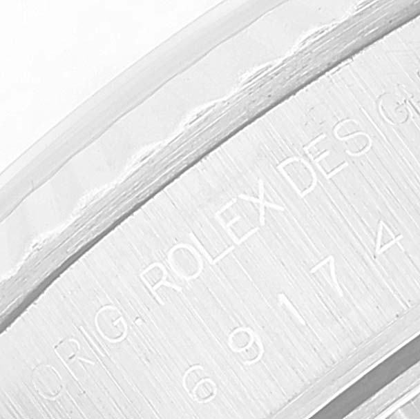 The image shows a close-up of the engraving on the side of the bezel of a Rolex Datejust 69174 Women's Stainless Steel Blue Dial 69174 Women's Stainless Steel Blue Dial watch.